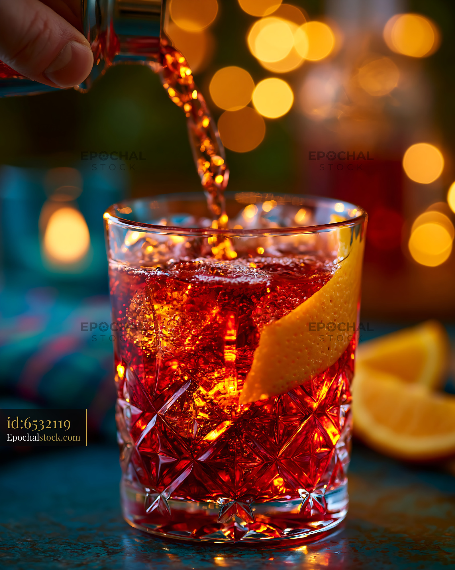 Watermarked full-resolution preview of Pouring a drink into a glass with ice and a garnish