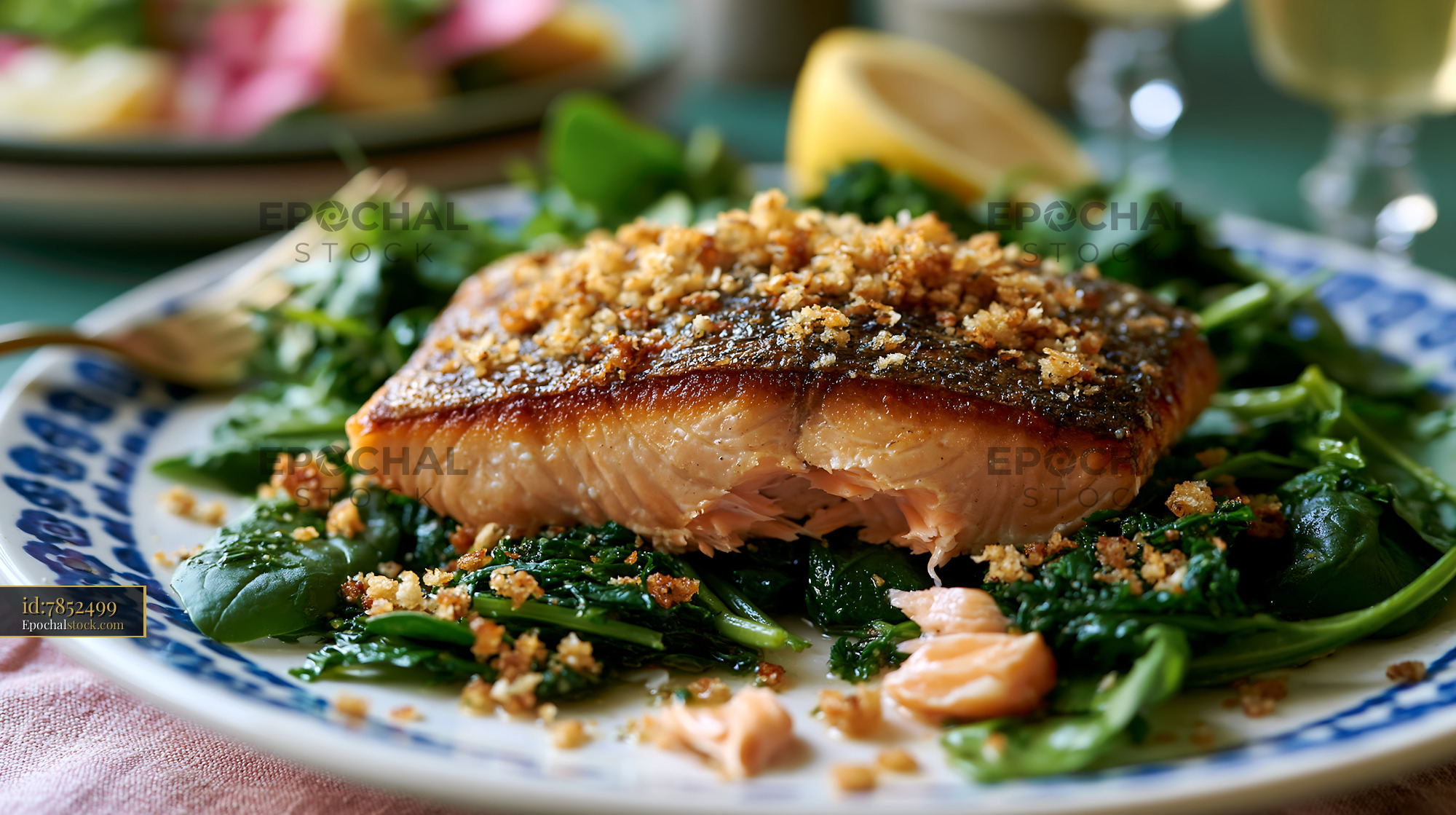 Watermarked full-resolution preview of Salmon fillet served on a bed of spinach with bread crumbs