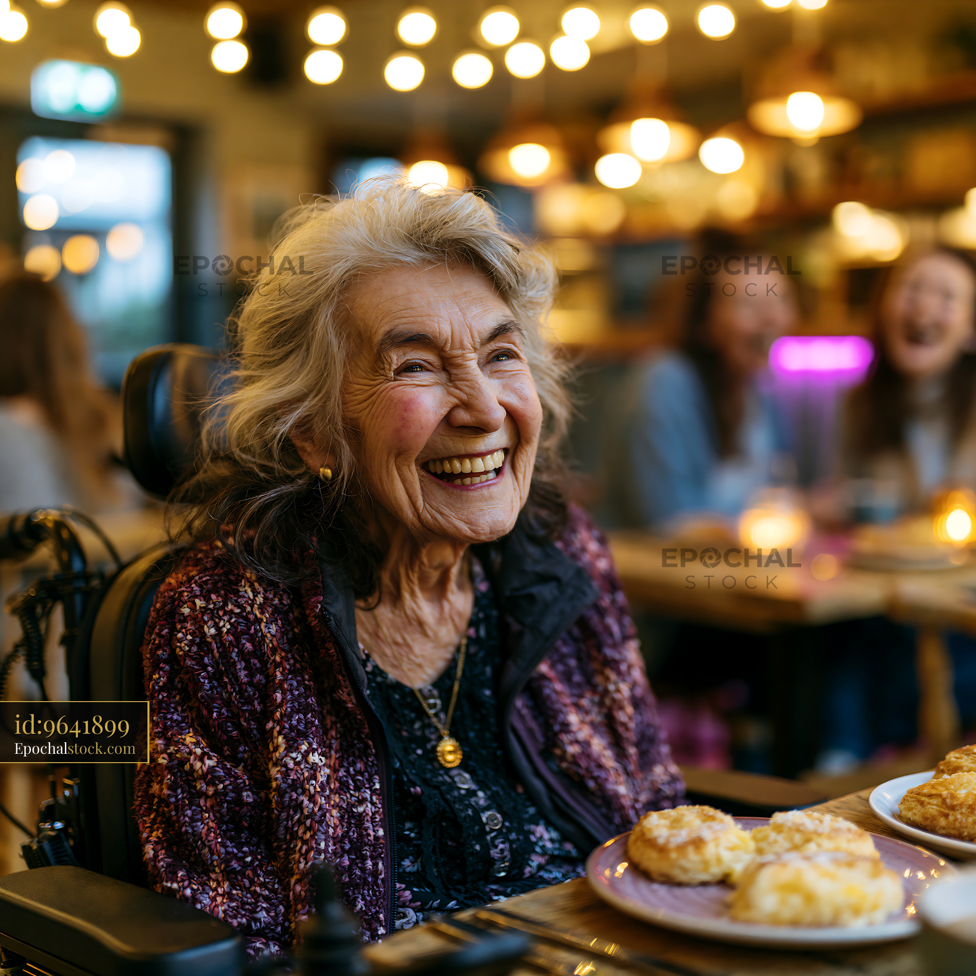 Watermarked full-resolution preview of Elderly woman smiling in cafe with friends and snacks on table