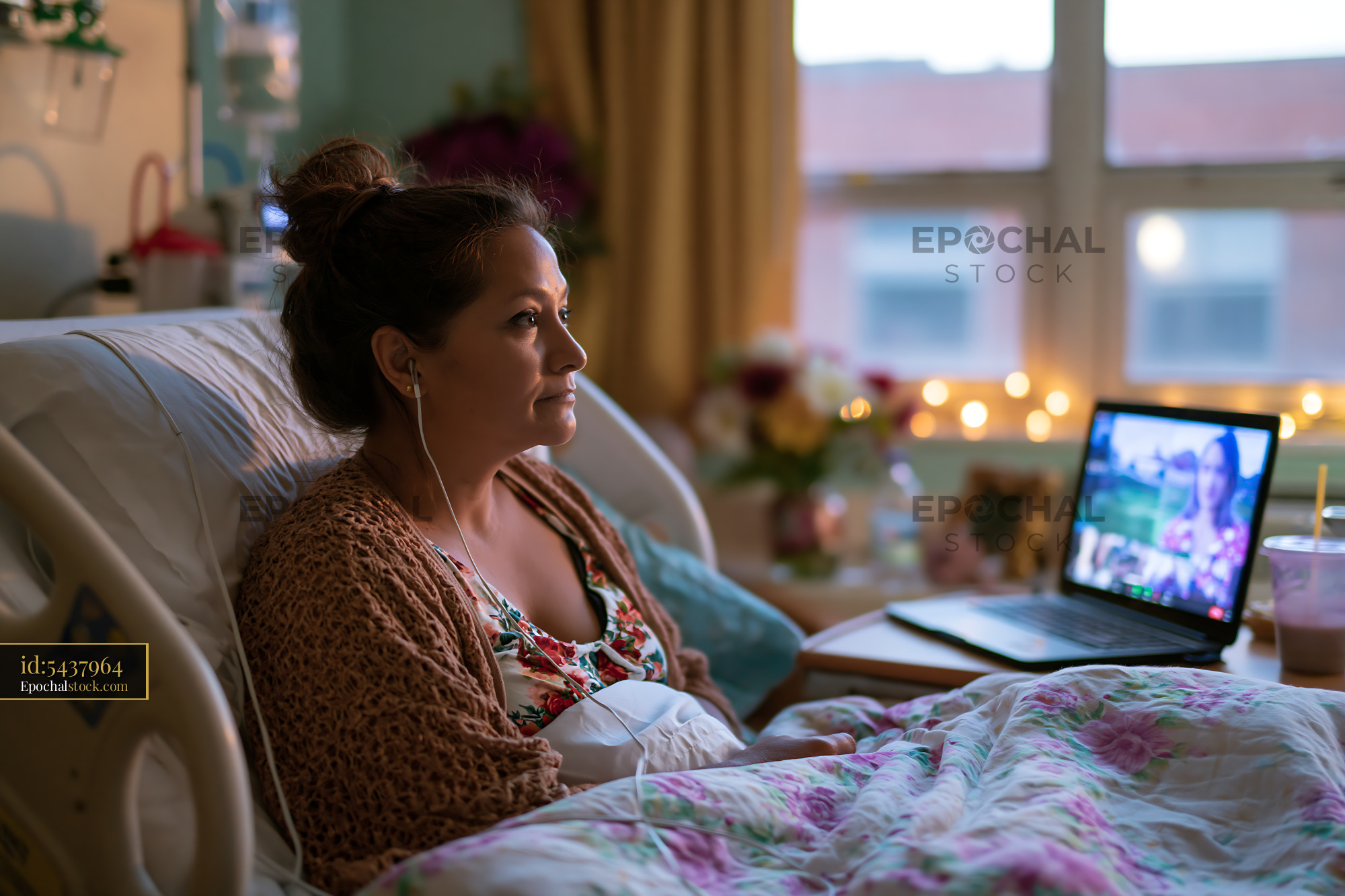 Watermarked full-resolution preview of Woman using a laptop while resting in bed