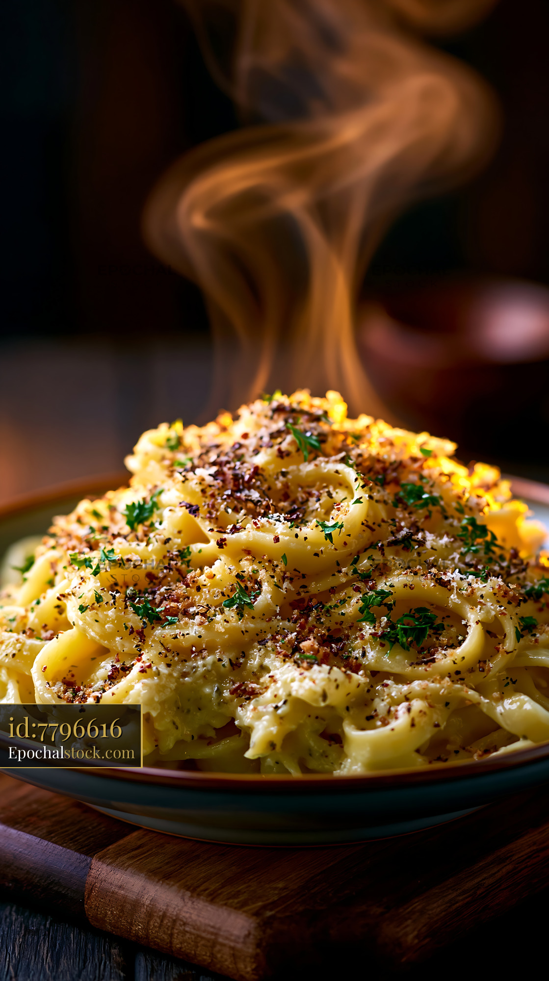 Watermarked full-resolution preview of Freshly cooked pasta with steam and herbs on a wooden table