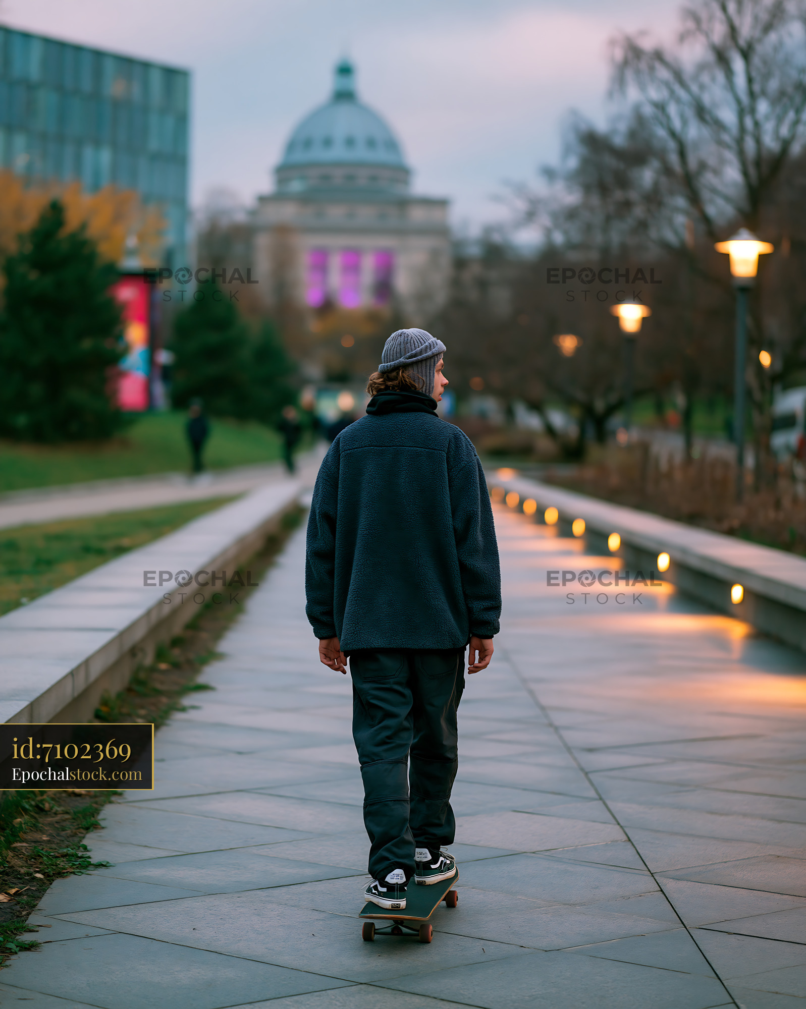 Young Man Skating on a Pathway in the City at Dusk - stock photo