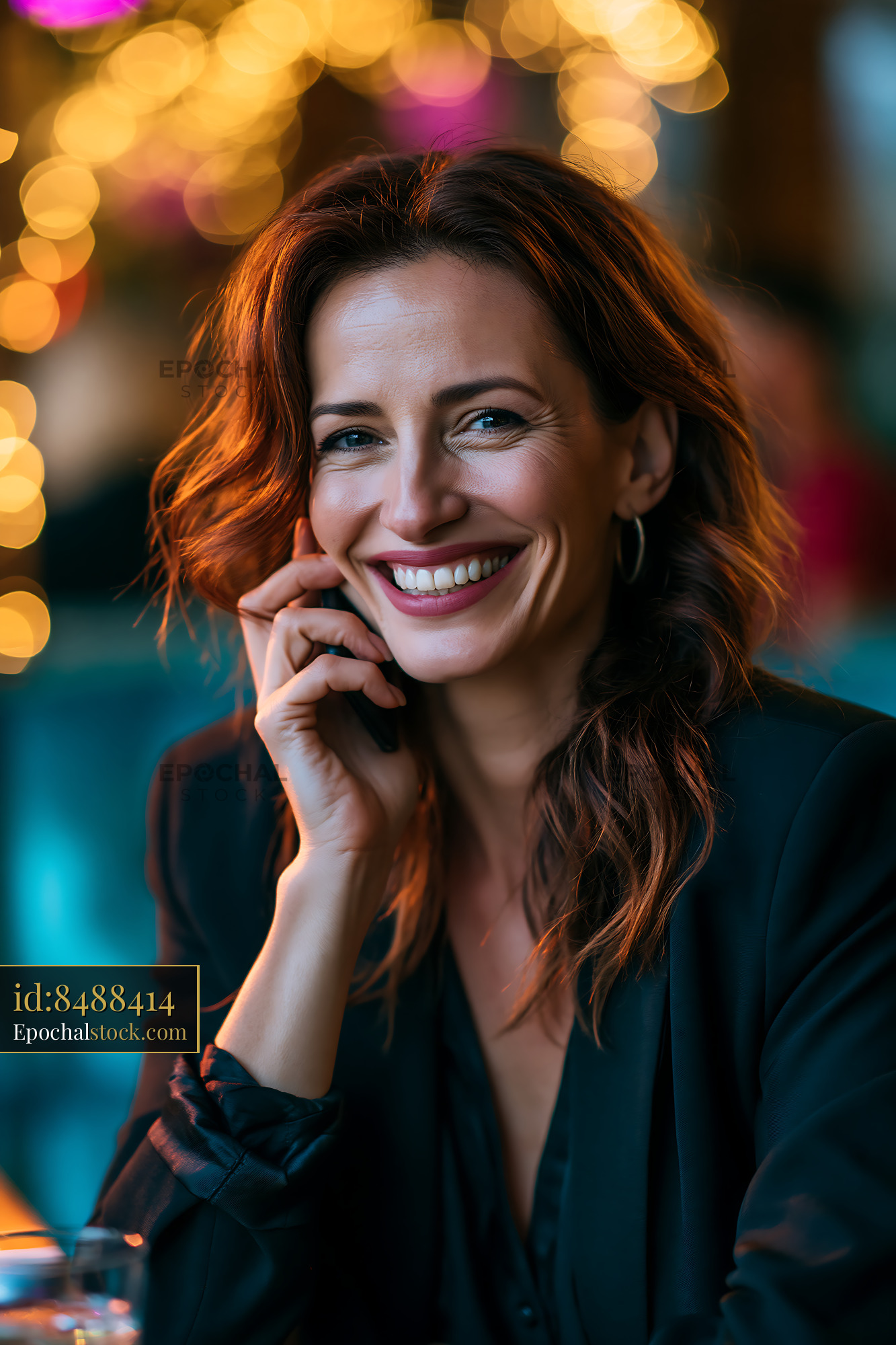 Watermarked full-resolution preview of Smiling woman with wavy hair sitting at a table in a cafe