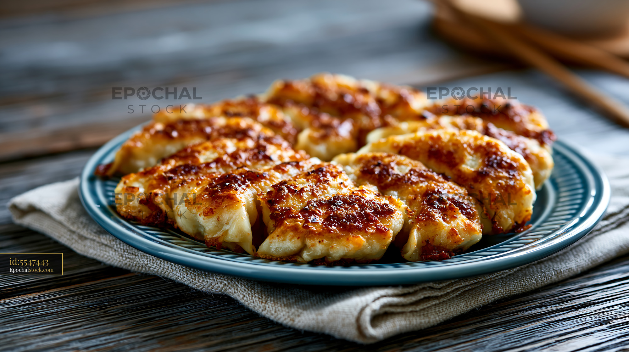 Watermarked full-resolution preview of Delicious pan-fried dumplings served on a blue plate