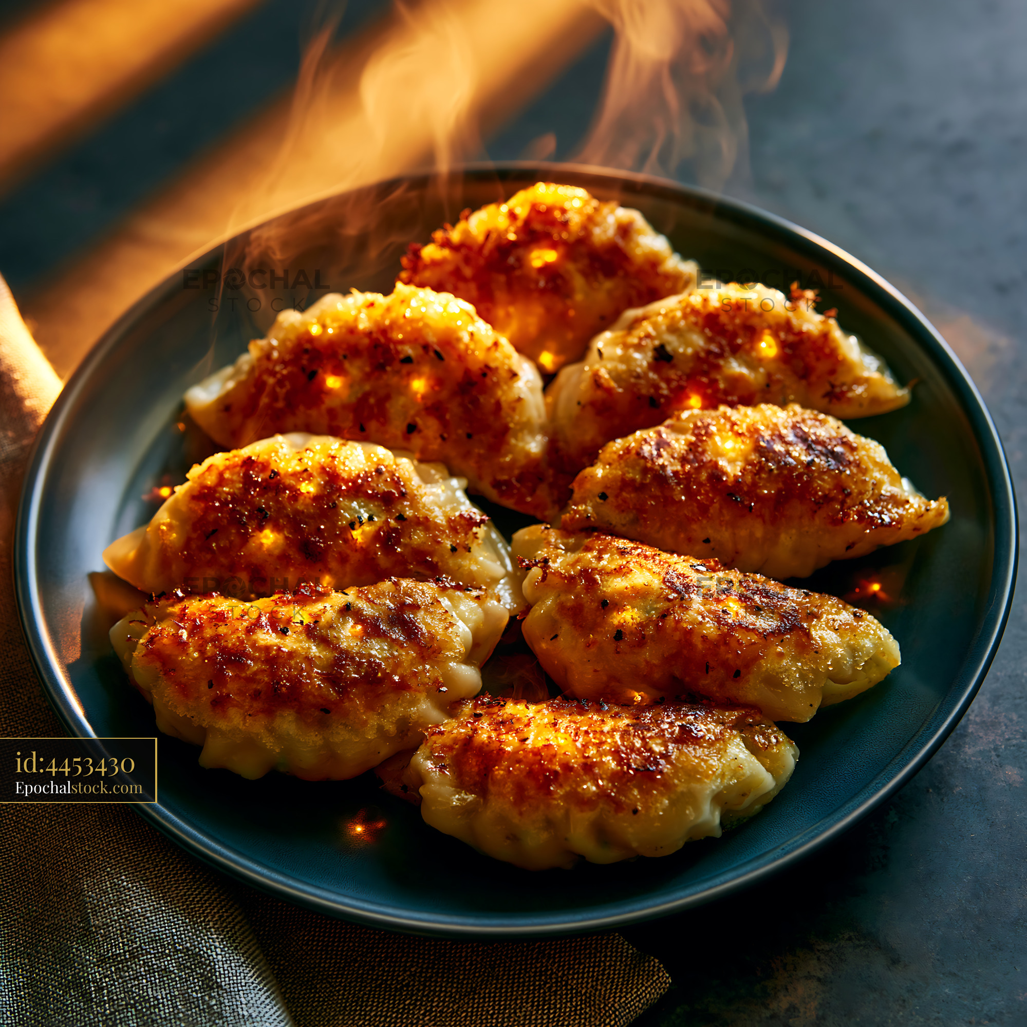 Watermarked full-resolution preview of Golden dumplings on a dark plate with steam rising