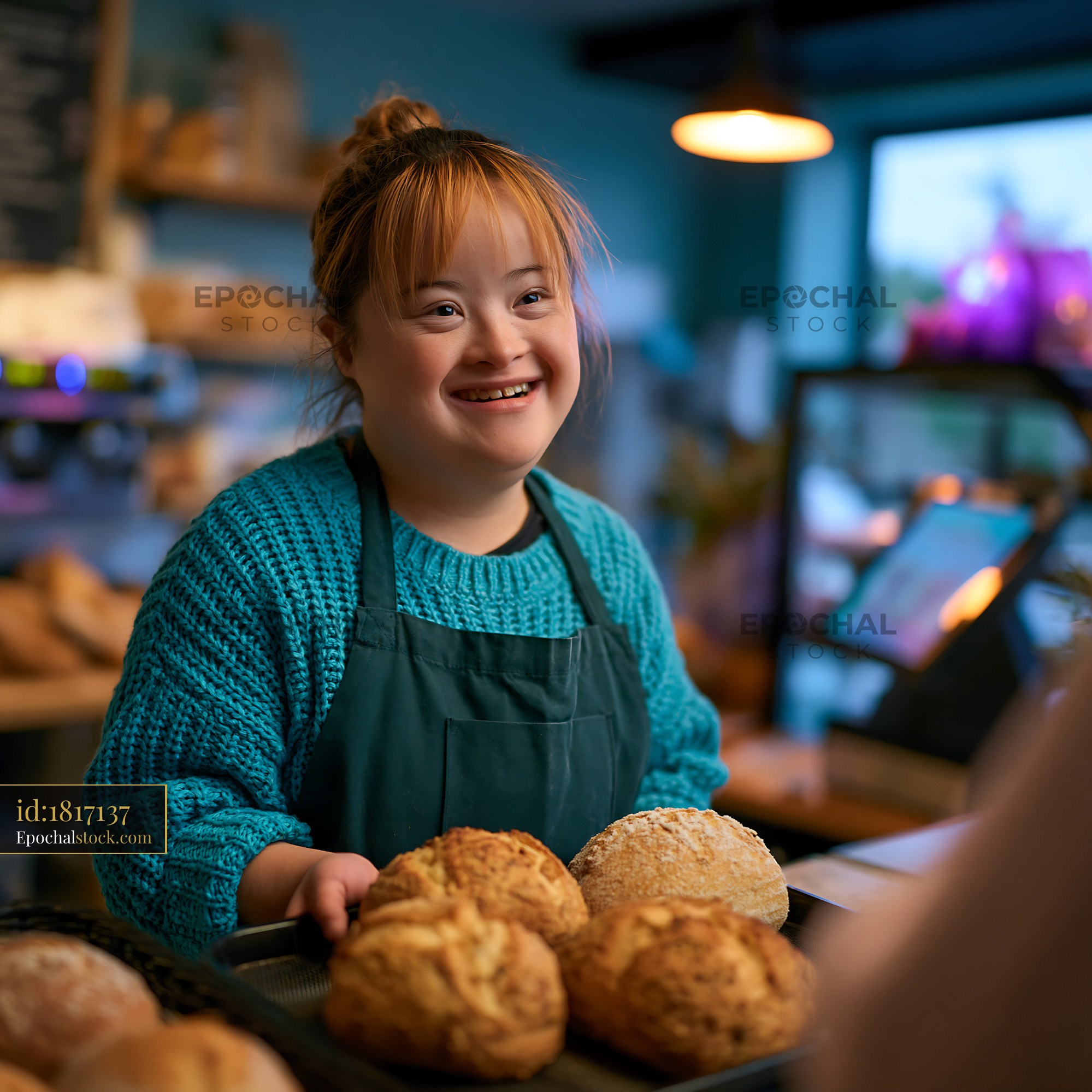 Watermarked full-resolution preview of Young woman serving fresh bread in a bakery