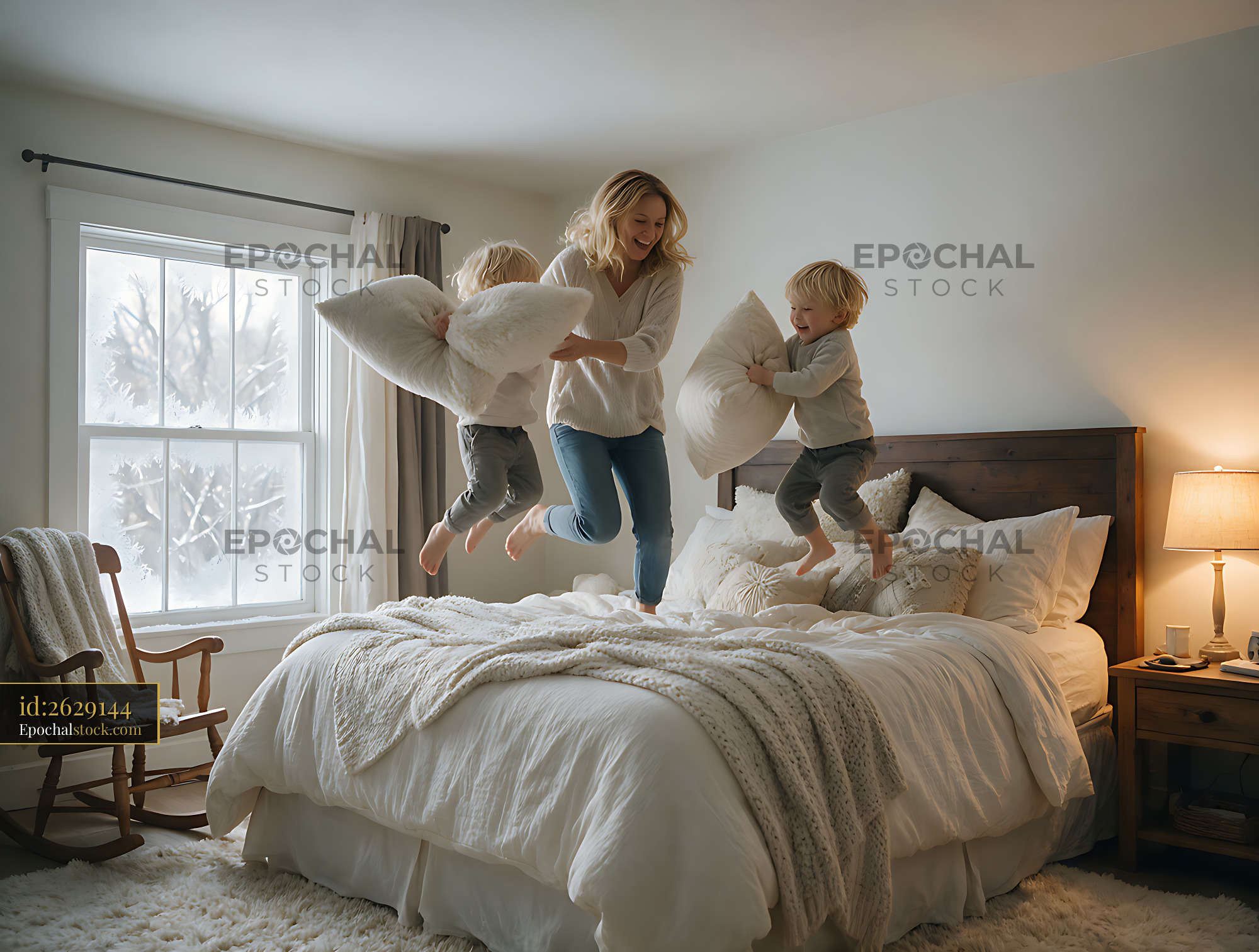 Watermarked full-resolution preview of Mother and children having a playful pillow jump