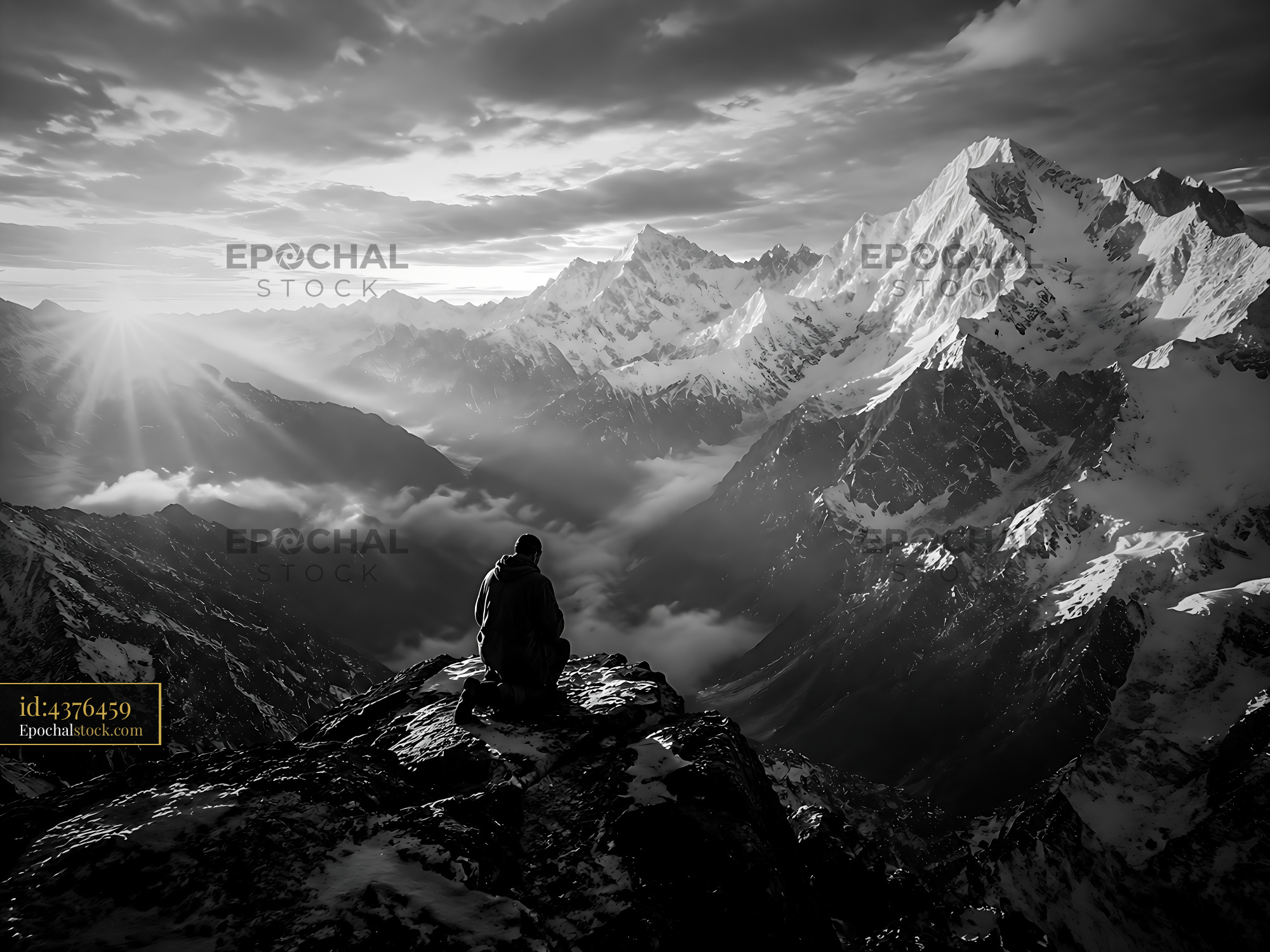Person Sitting on Mountain Edge Looking Over Valley at Sunset - stock photo