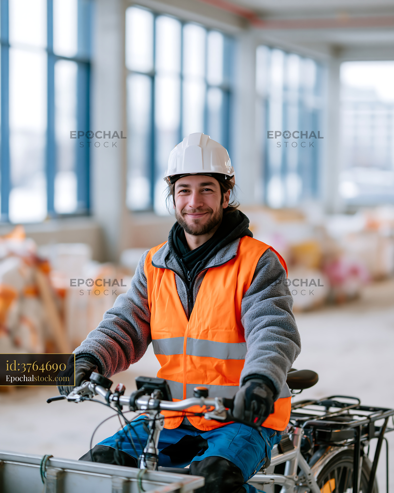Watermarked full-resolution preview of Worker on bicycle in construction site wearing safety gear
