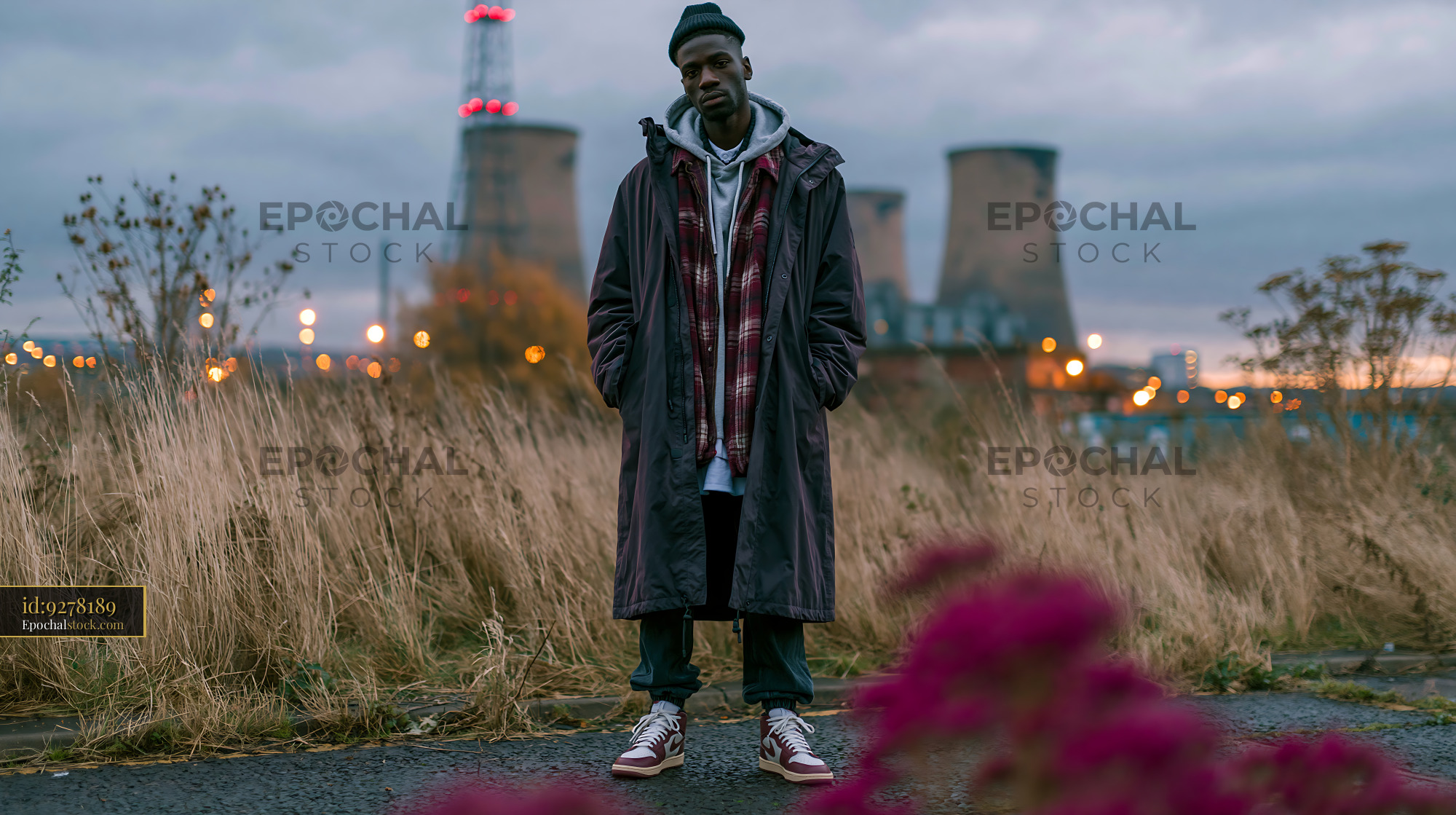 Watermarked full-resolution preview of Man standing in an industrial area with power plant in the background