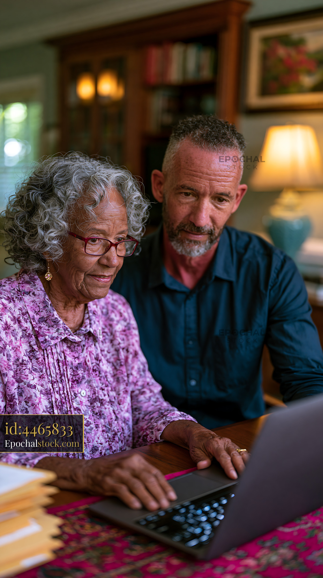 Watermarked full-resolution preview of Man and woman working on a laptop at home in the living room