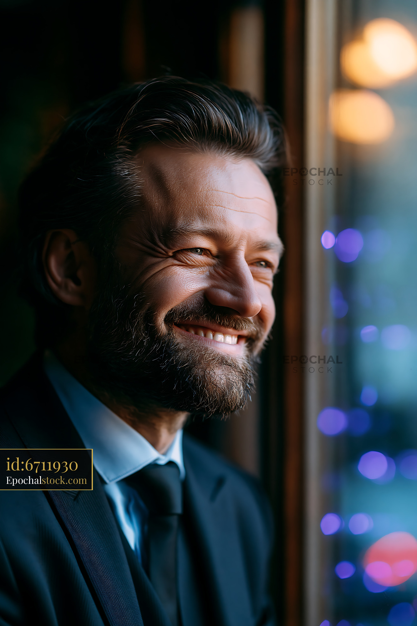 Man Smiling While Looking out the Window During Evening Hours - stock photo