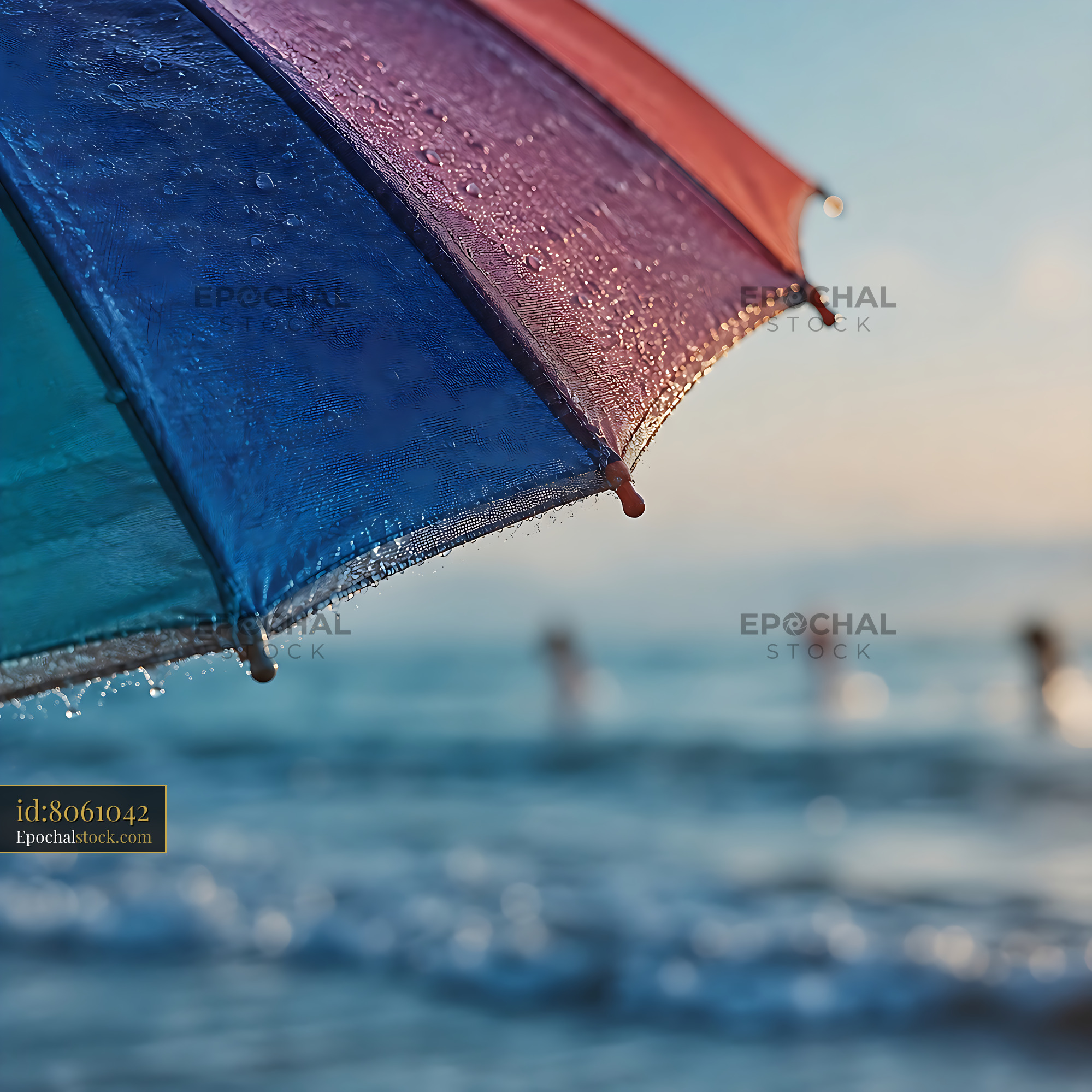 Umbrella Provides Shade on Beach as People Swim in Ocean - stock photo