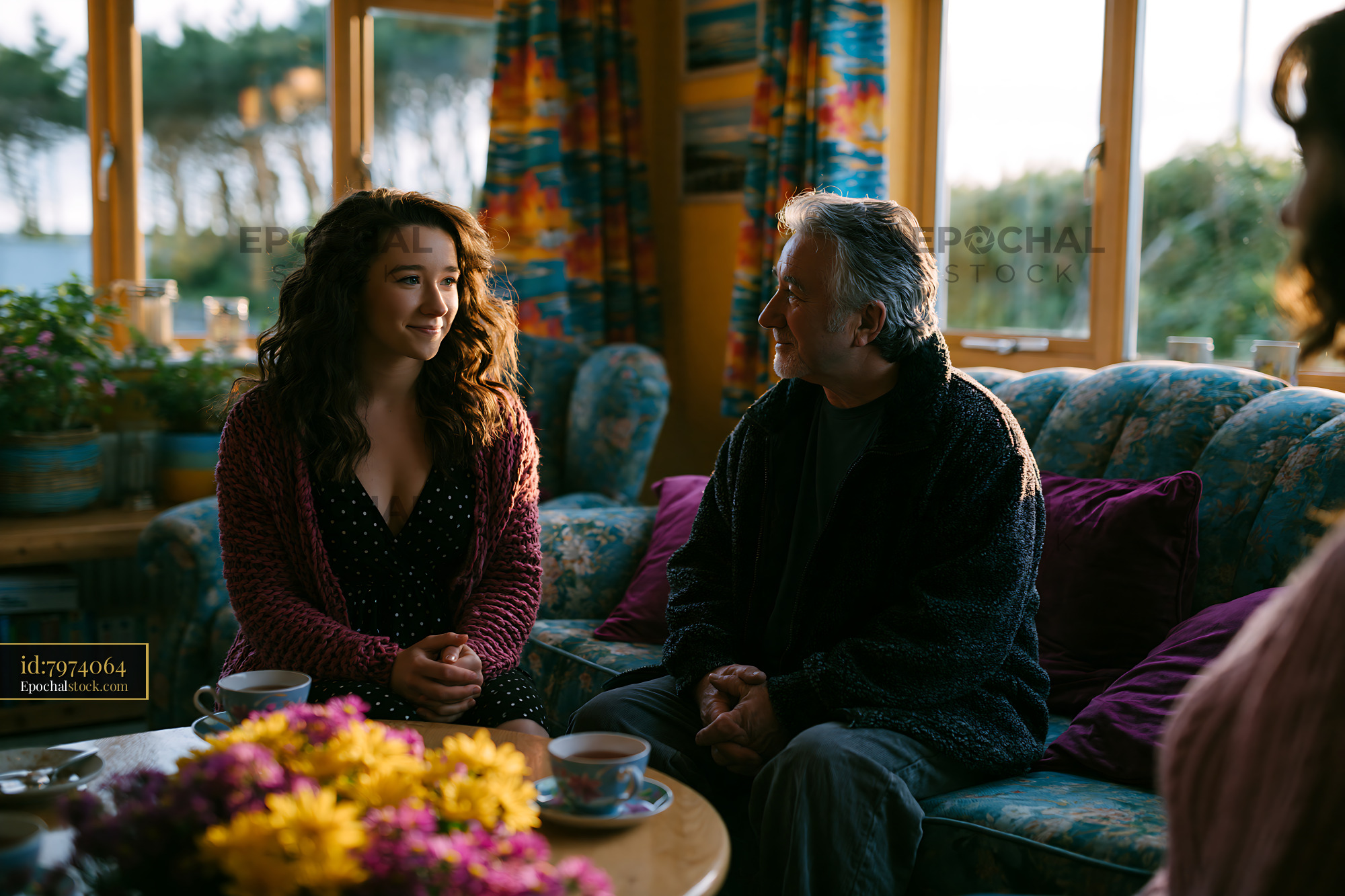 Watermarked full-resolution preview of People sitting in living room with sunlight and flowers