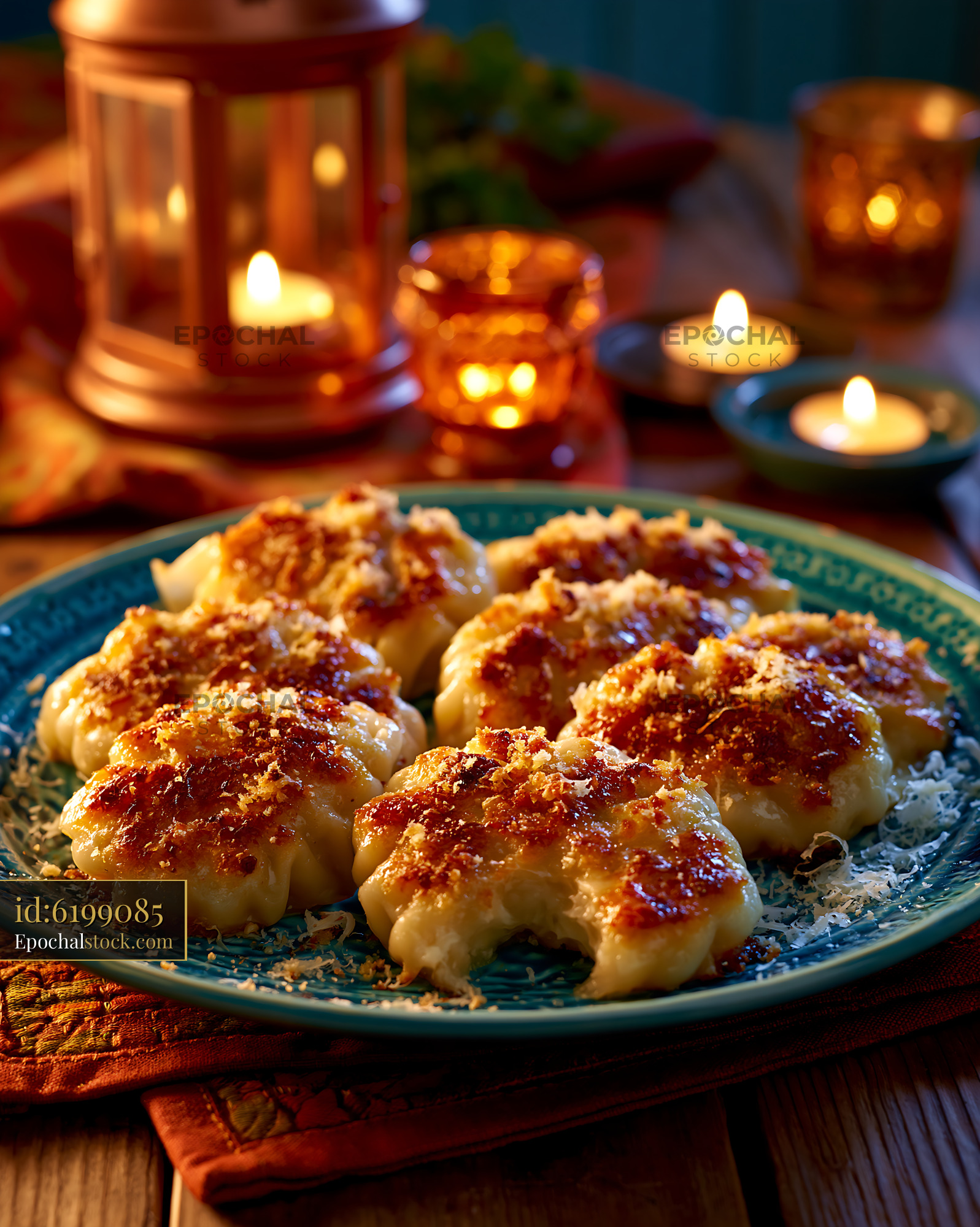 Watermarked full-resolution preview of Delicious dumplings served on a blue plate with candles around