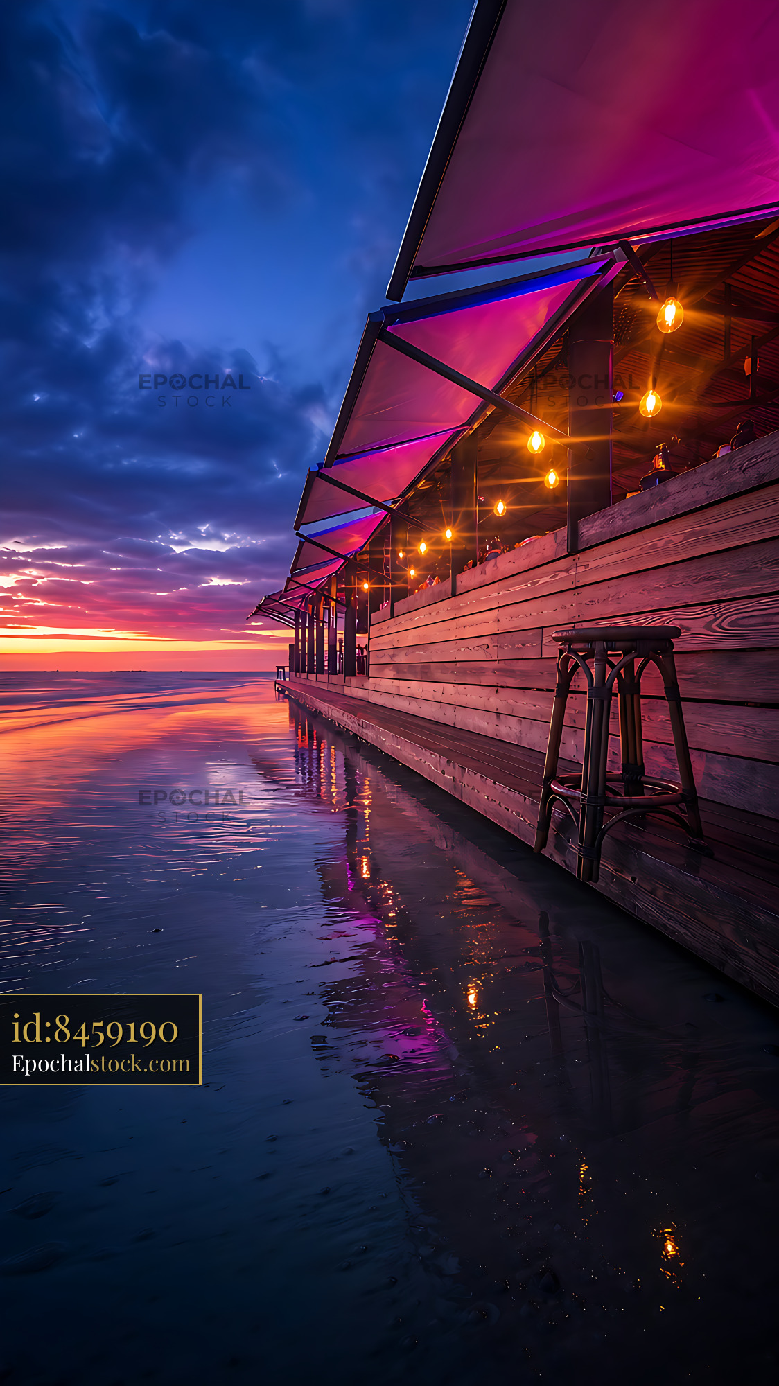Watermarked full-resolution preview of Sunset view of beachside restaurant with colorful lights