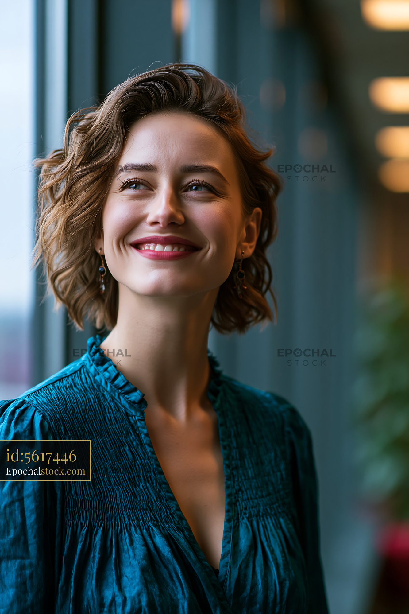 Watermarked full-resolution preview of Woman smiling indoors near large window