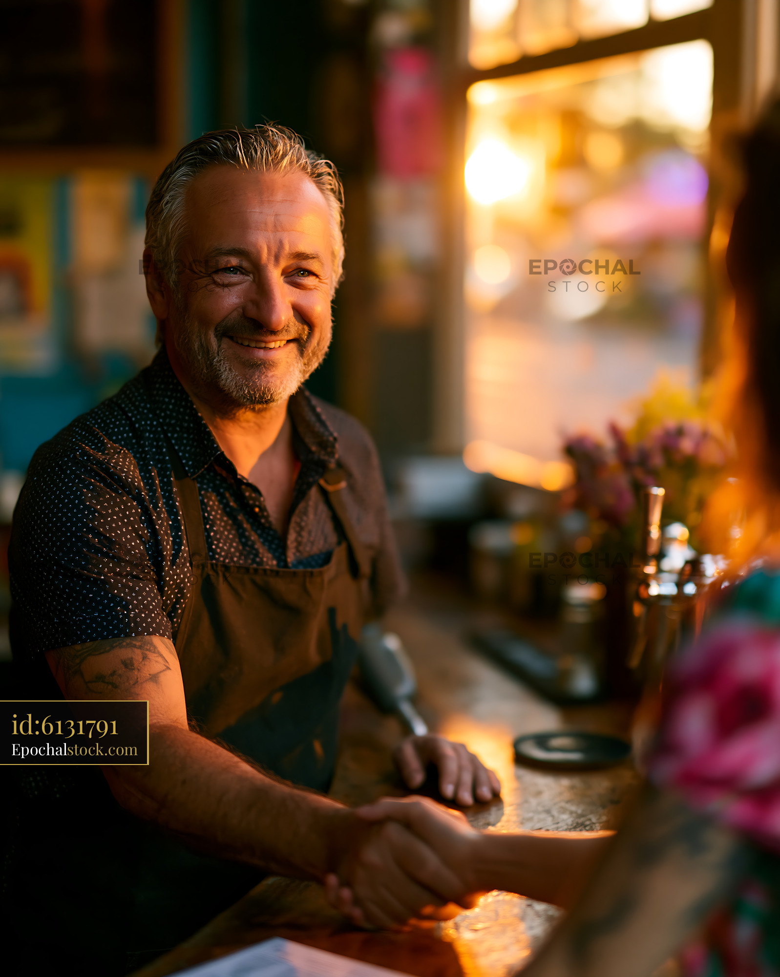 Watermarked full-resolution preview of Barista shakes hands with customer at cafe during sunset