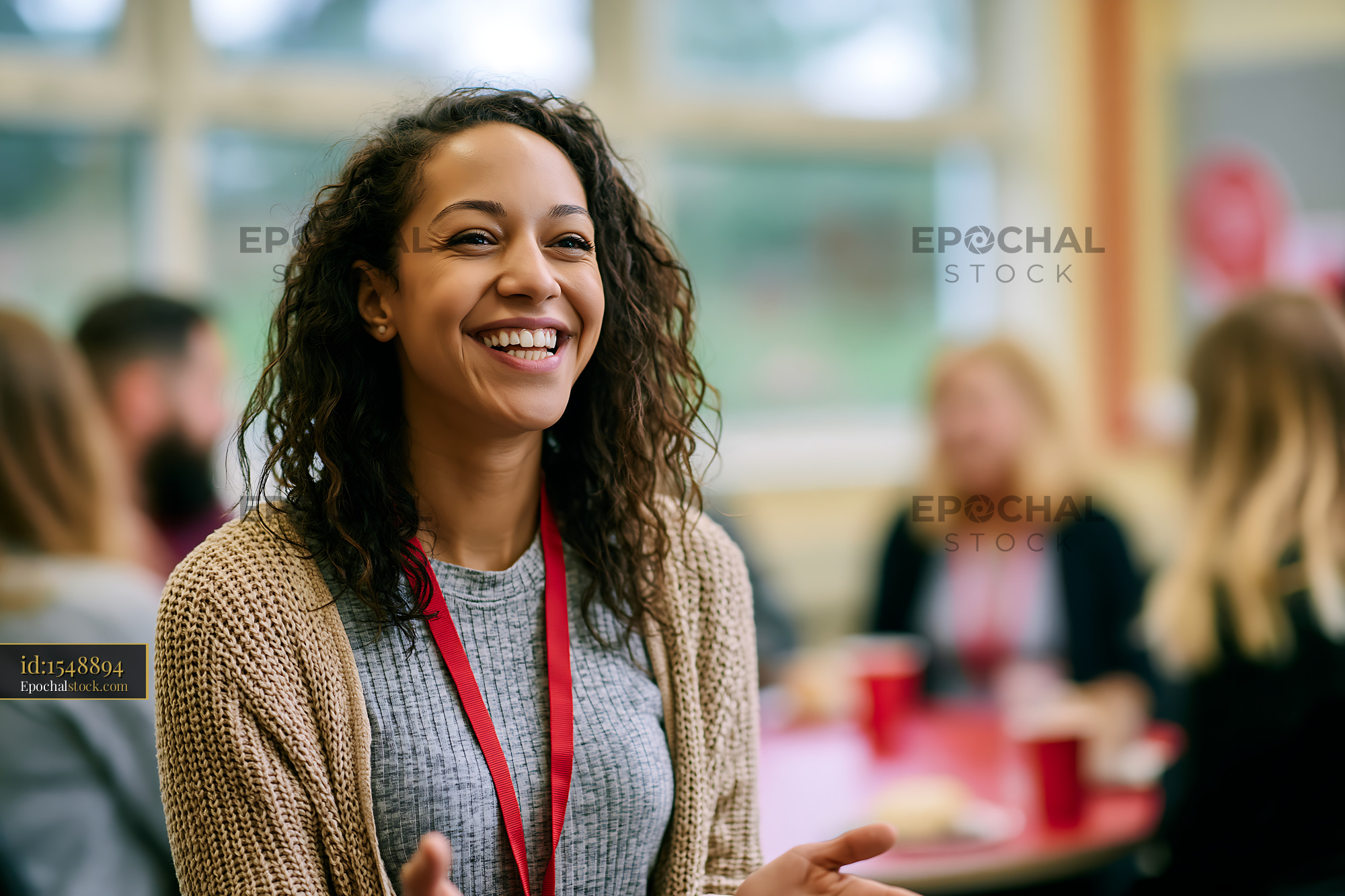 Watermarked full-resolution preview of Woman smiling during a group discussion in a casual setting
