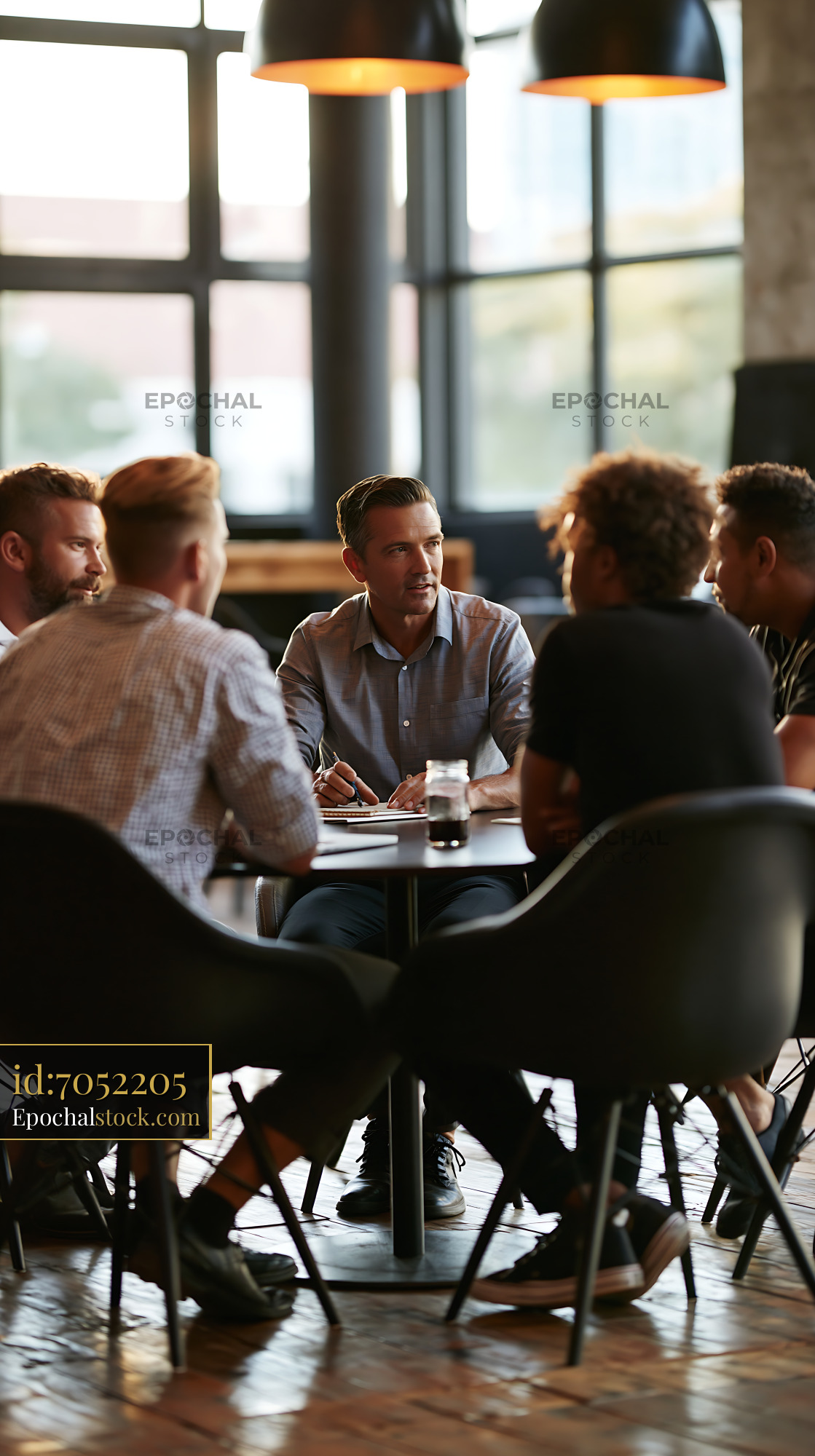 Watermarked full-resolution preview of Group discussion at a modern café with focused individuals