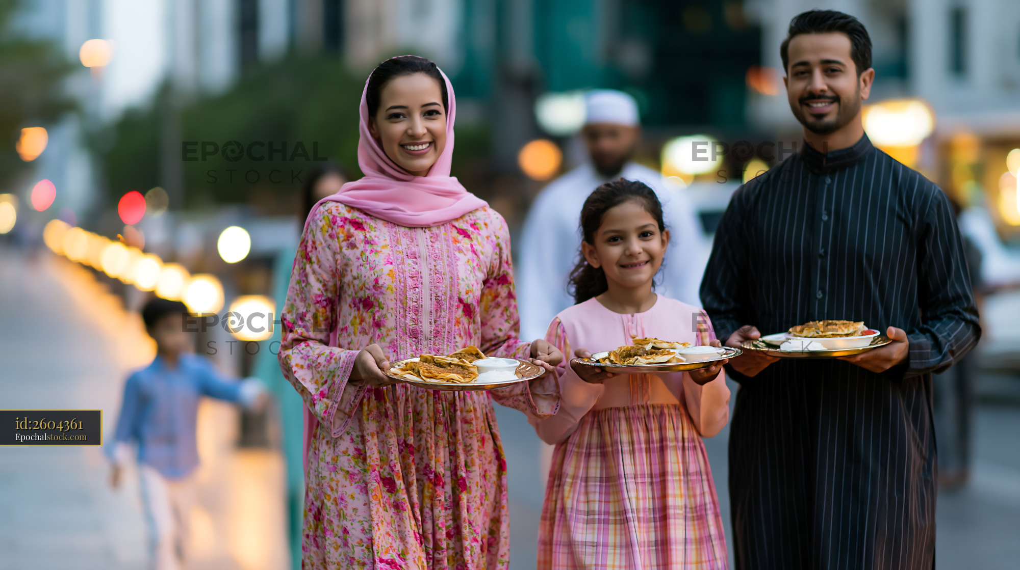 Watermarked full-resolution preview of Families enjoy a meal while walking on a city street at dusk