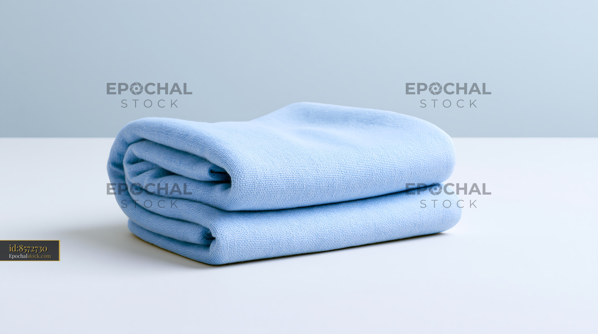 Watermarked full-resolution preview of Soft blue towel neatly folded on a light surface