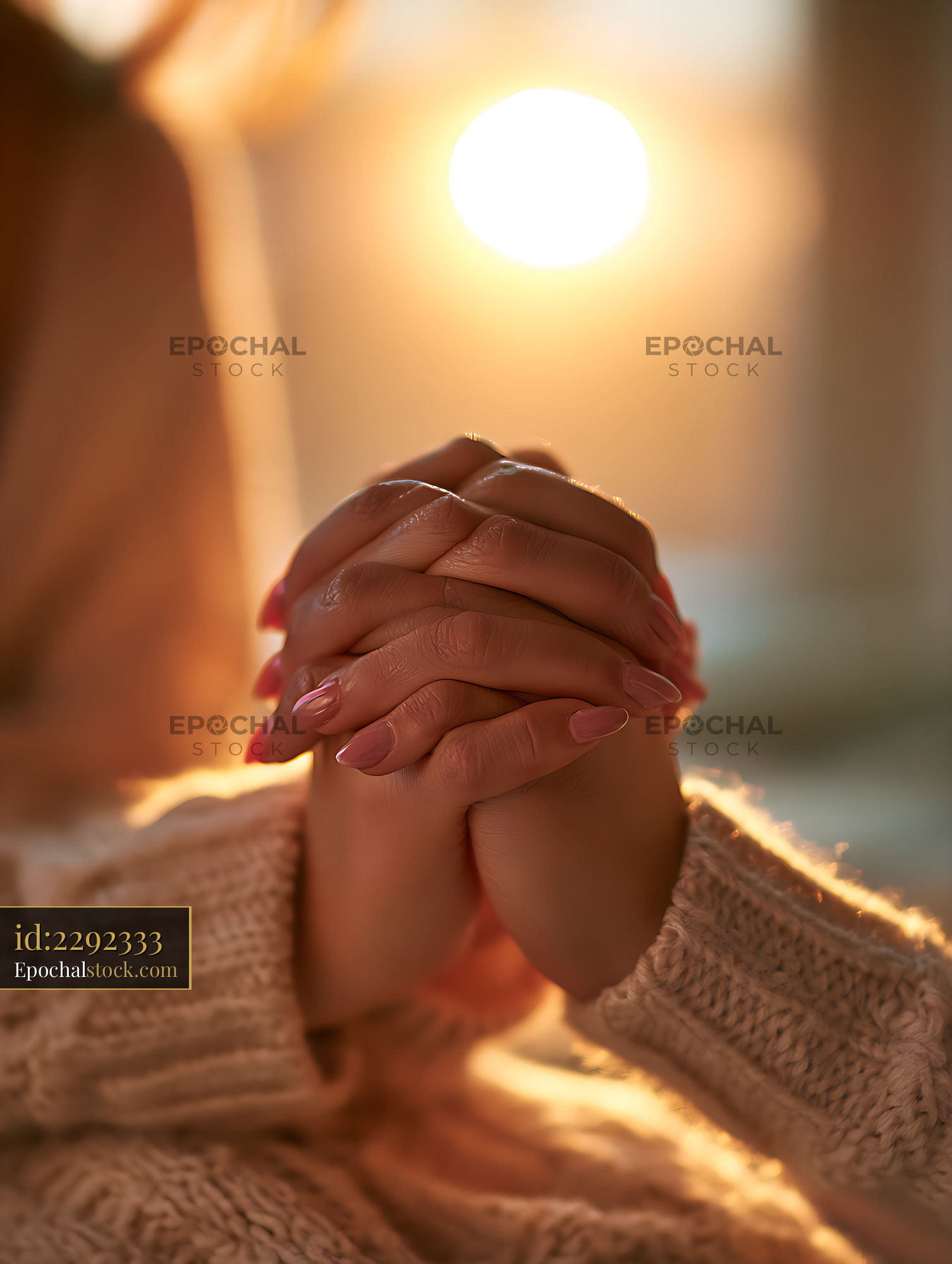 Watermarked full-resolution preview of Person holding clasped hands in golden light