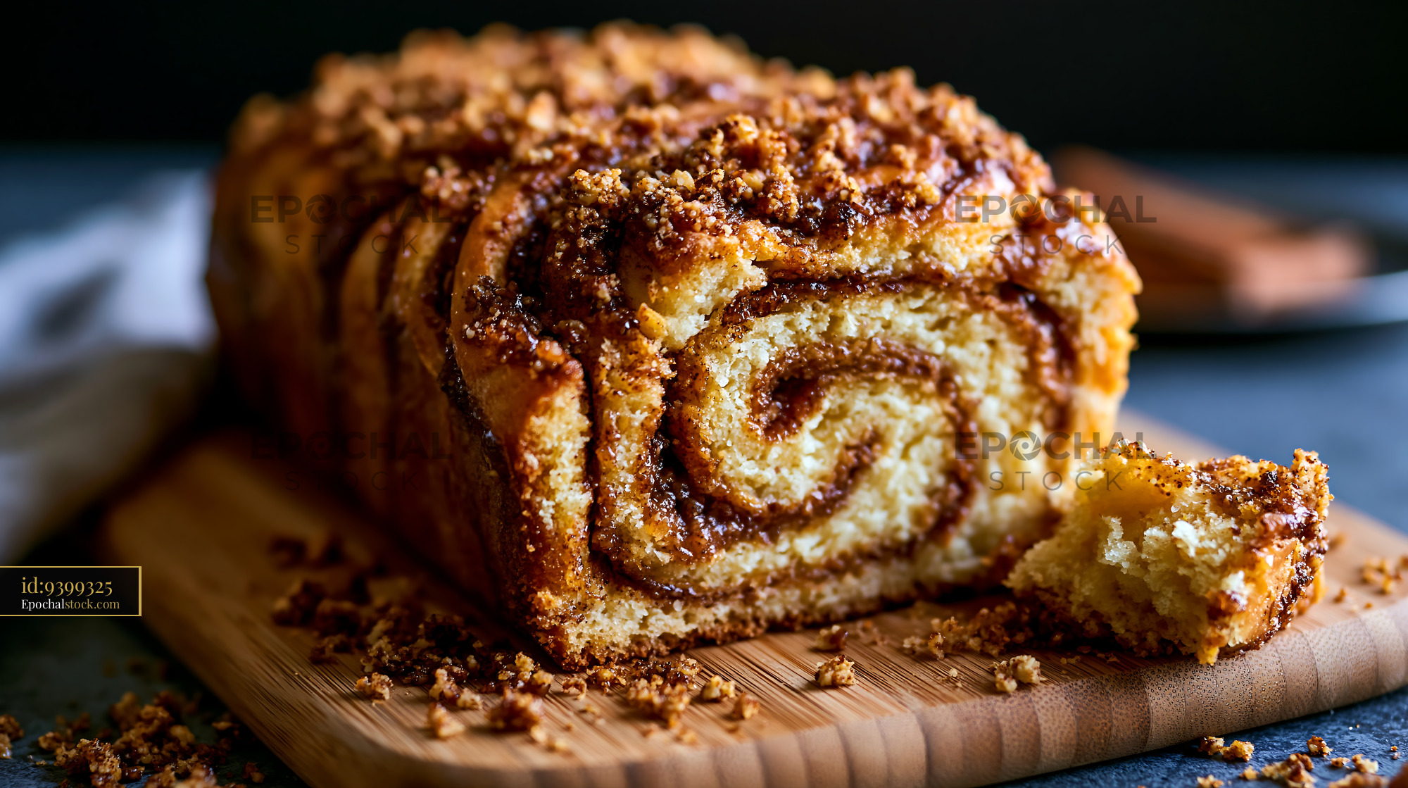 Watermarked full-resolution preview of Freshly baked cinnamon roll loaf on wooden cutting board
