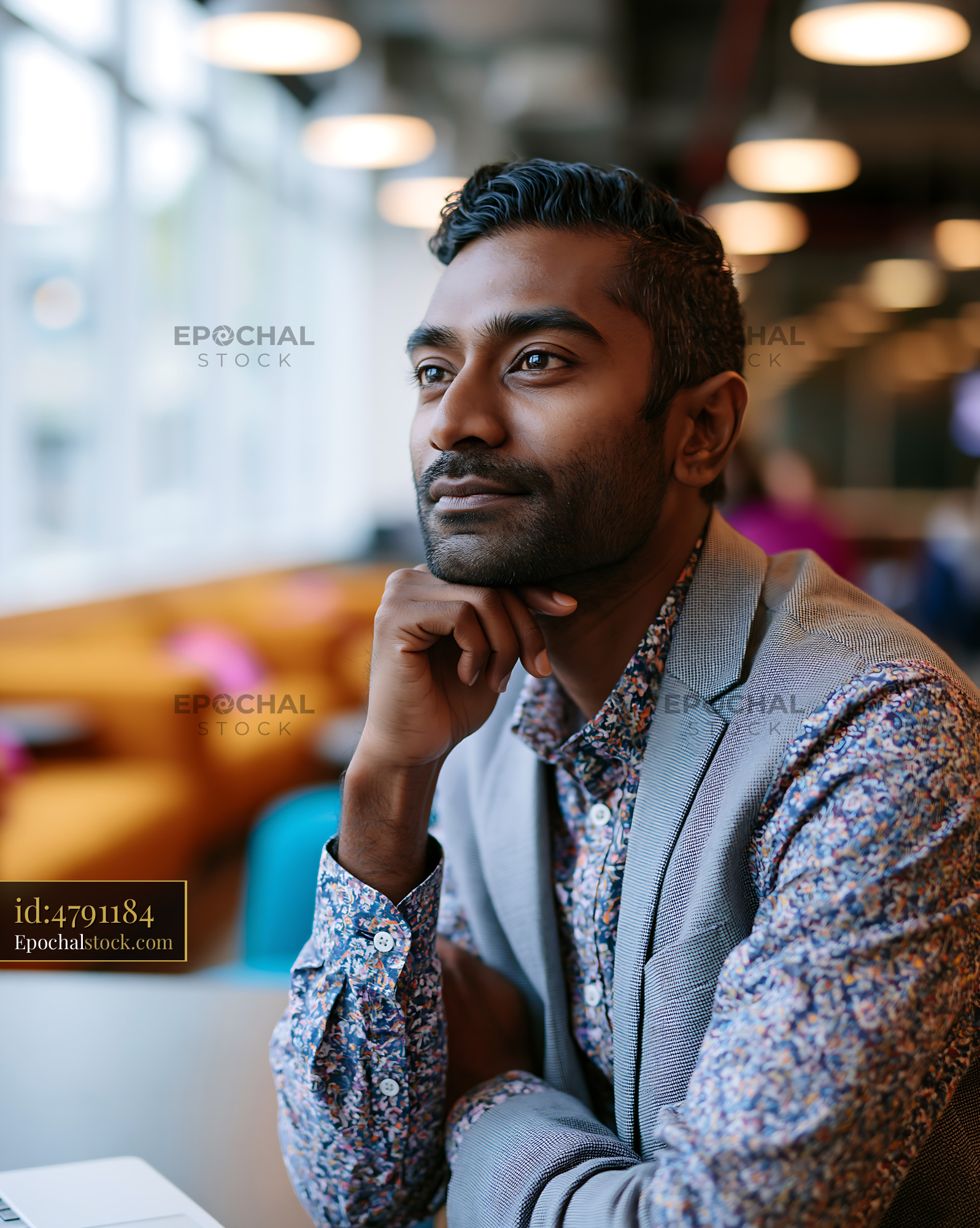 Watermarked full-resolution preview of Man thinking in modern office setting with bright windows