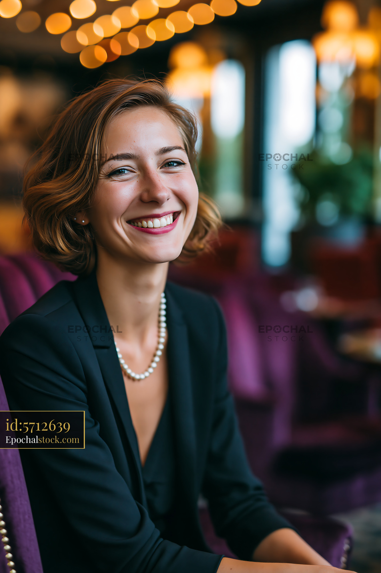 Watermarked full-resolution preview of Smiling woman wearing pearls in a stylish interior setting