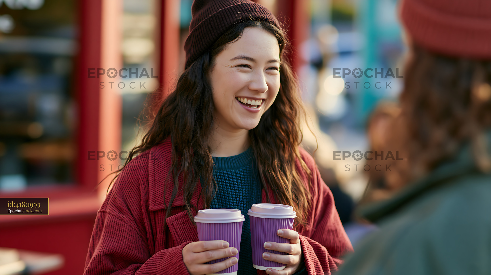 Watermarked full-resolution preview of Smiling woman holding coffee cups in busy street