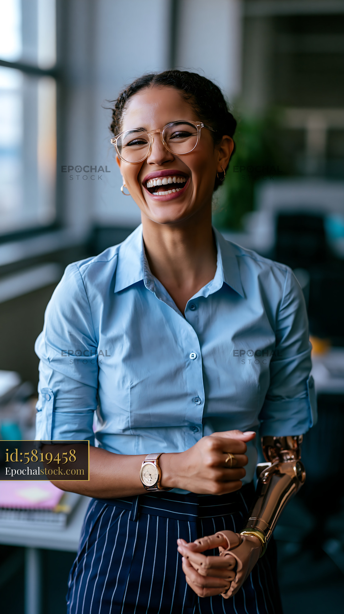 Watermarked full-resolution preview of Woman smiles while working in modern office with a prosthetic arm
