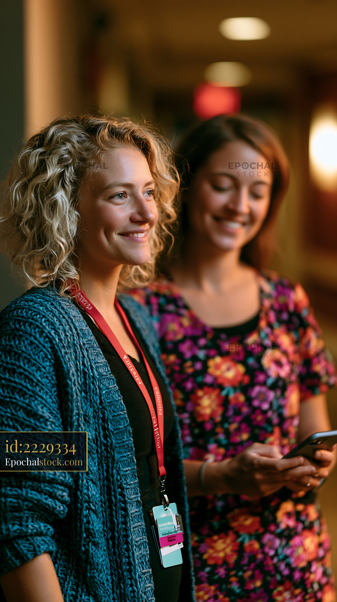 Watermarked full-resolution preview of Two women standing in a corridor with smiles on their faces