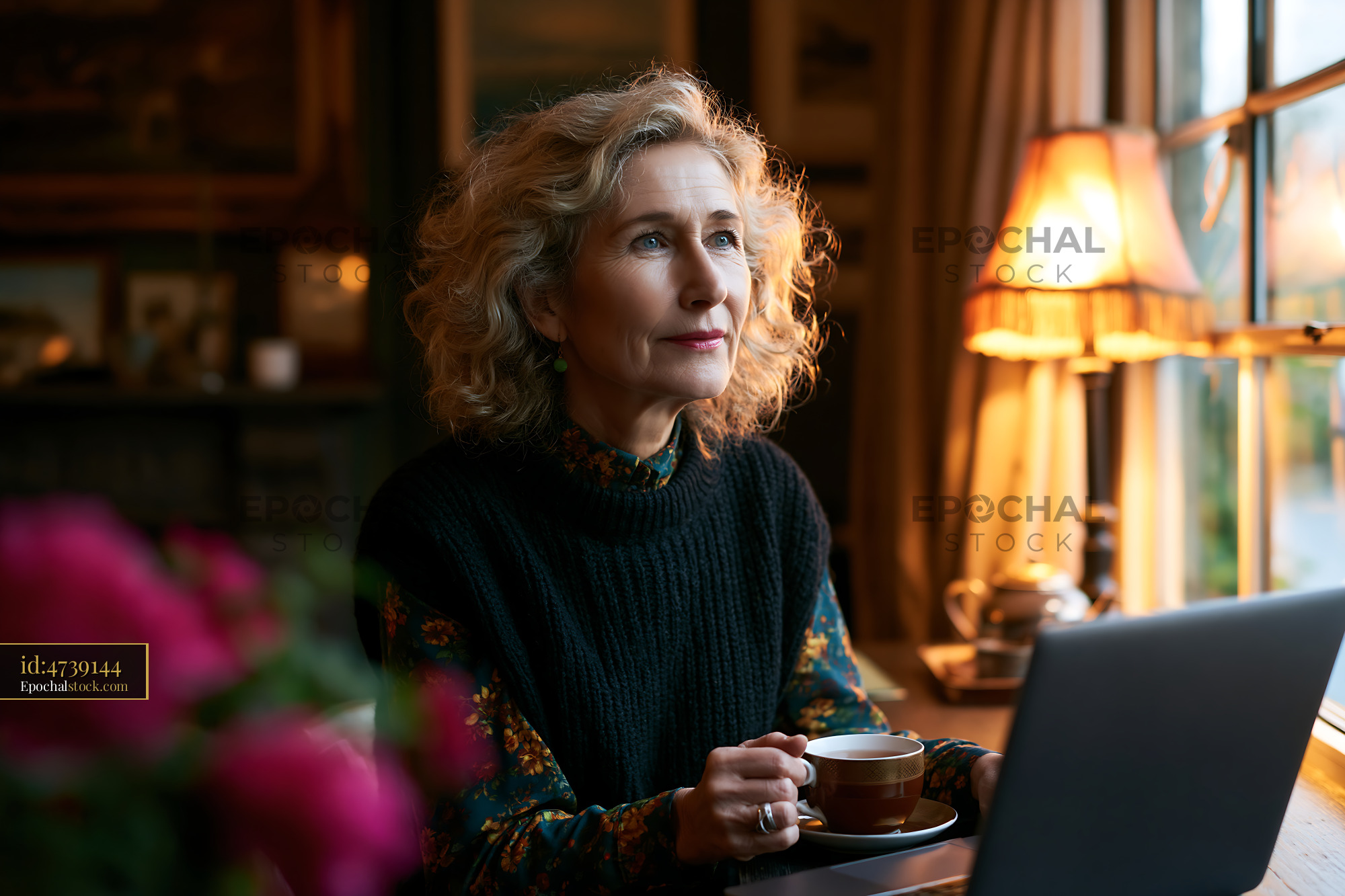 Watermarked full-resolution preview of Woman sitting by a window while drinking coffee