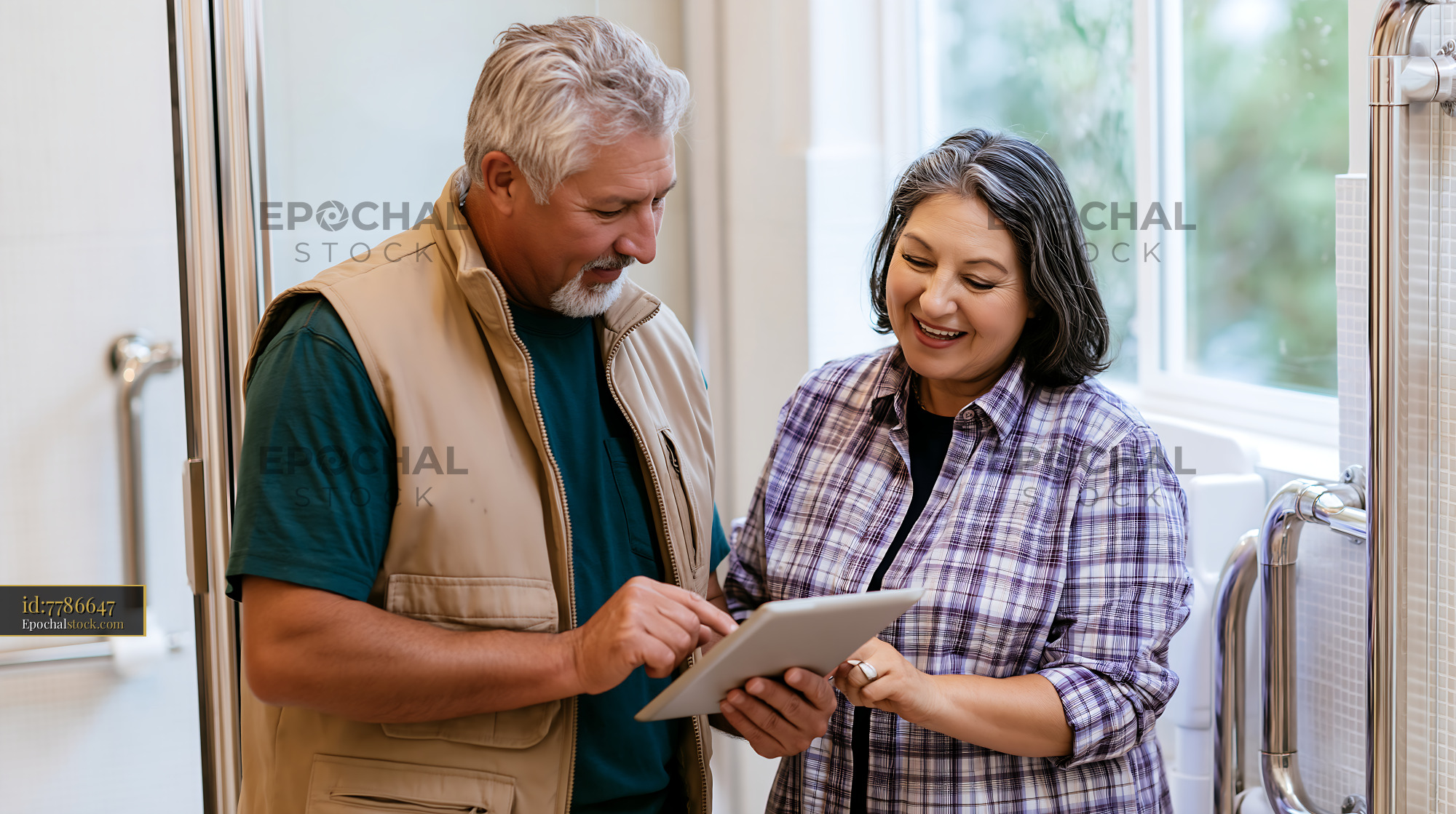 Watermarked full-resolution preview of Couple discussing plans together in home bathroom