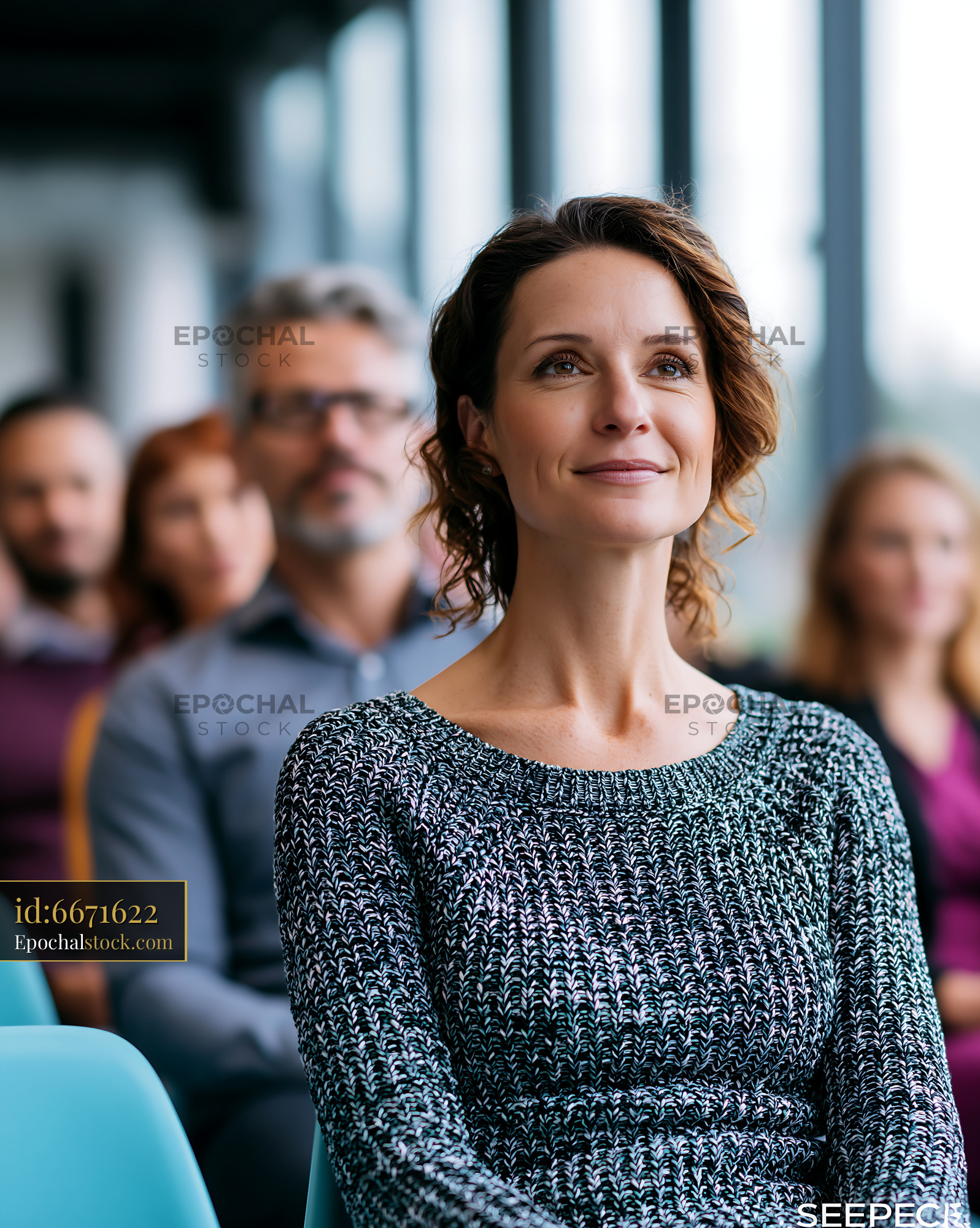Watermarked full-resolution preview of Audience member listening at a conference in a large room