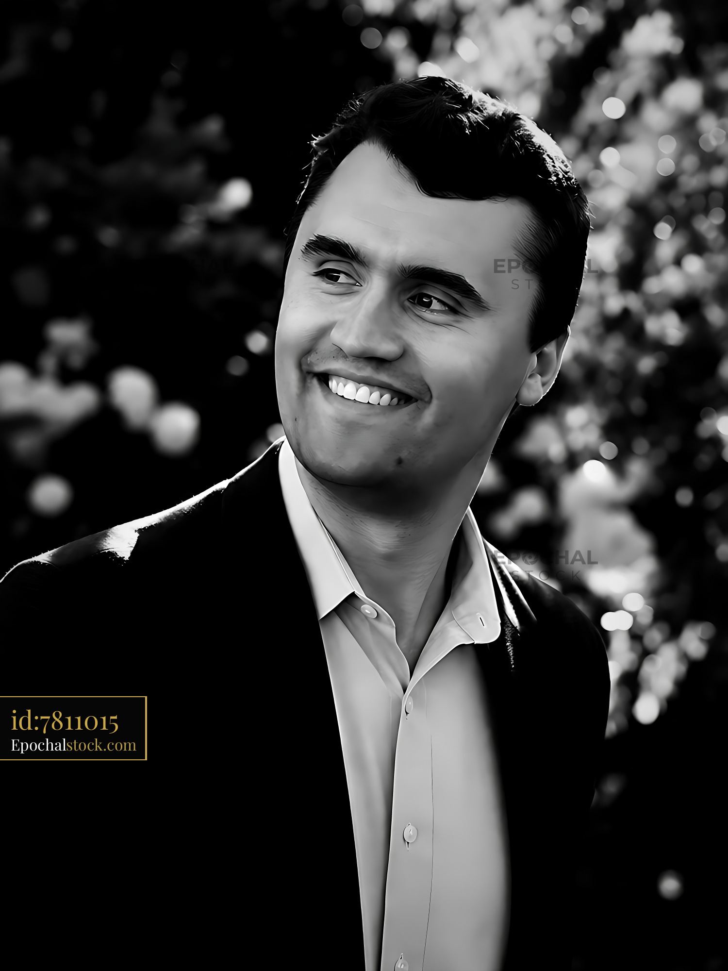Watermarked full-resolution preview of Man smiling outdoors with blurred floral background