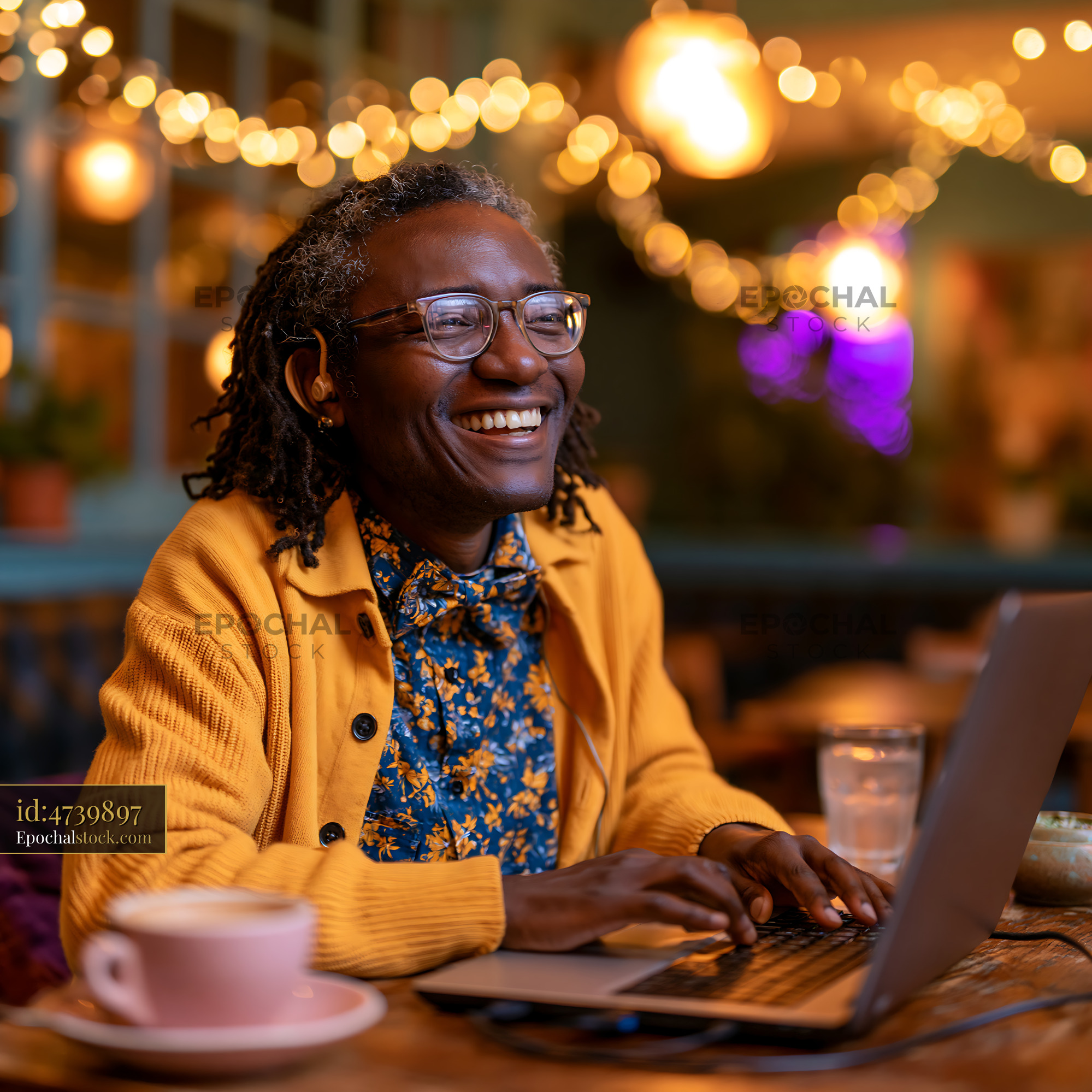 Watermarked full-resolution preview of Smiling person working on laptop in cozy cafe with warm lighting
