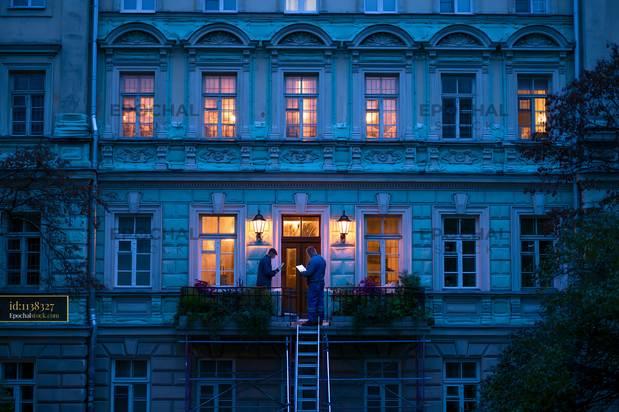 Watermarked full-resolution preview of Workers restoring a historic building at night near the entrance