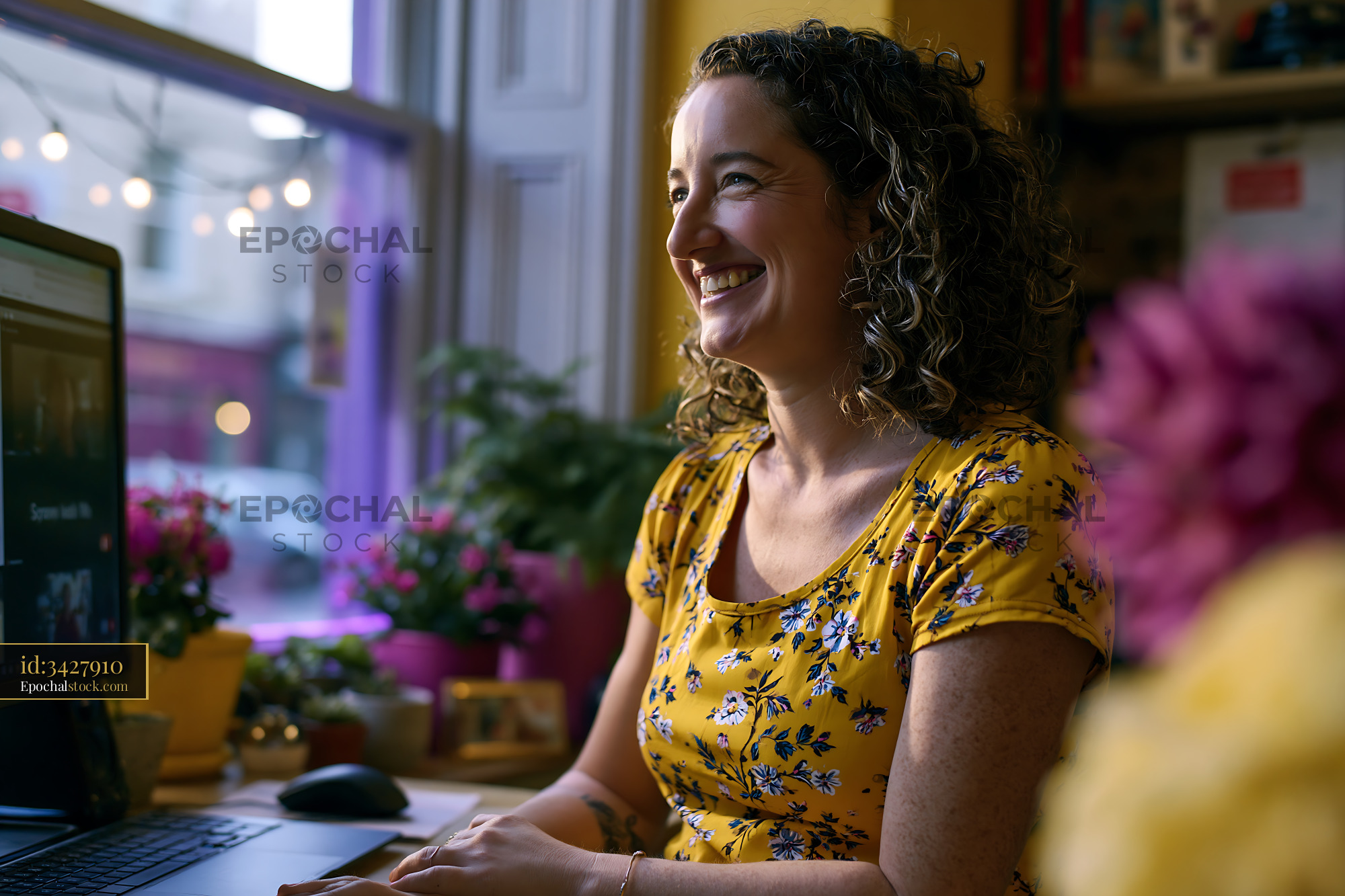 Watermarked full-resolution preview of Woman sitting at a desk with a computer and smiling