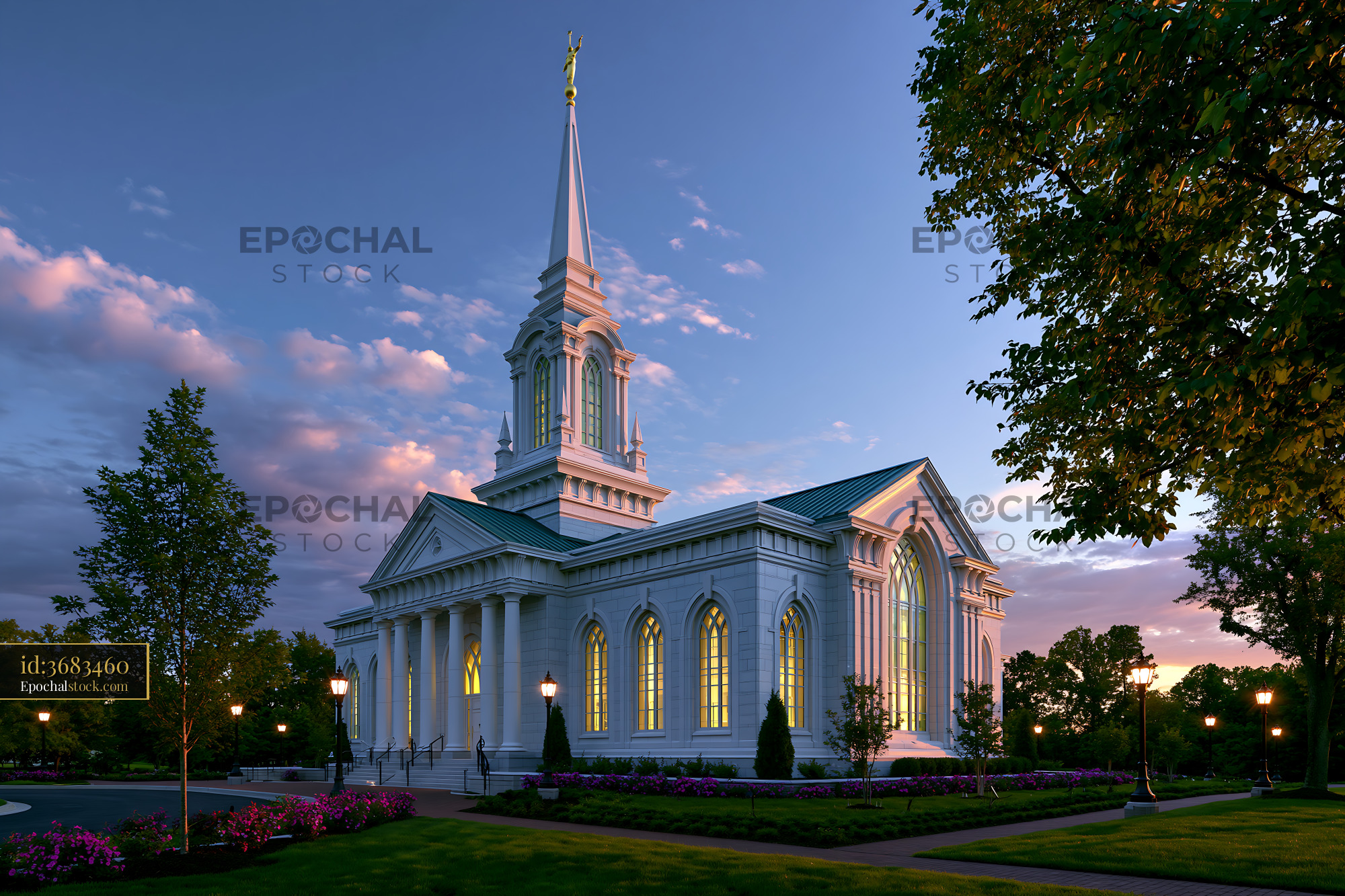 Watermarked full-resolution preview of Church building illuminated at dusk with trees and flowers