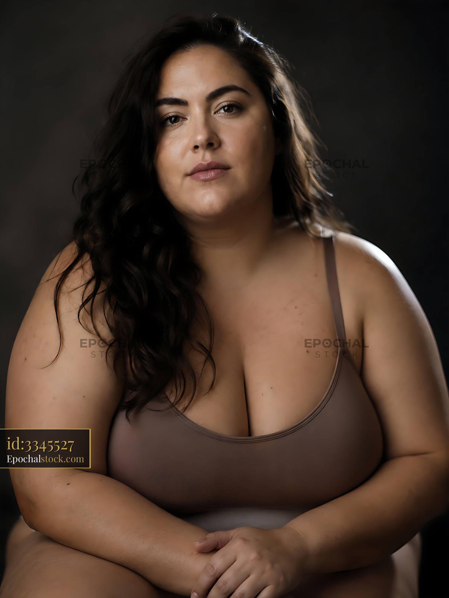 Watermarked full-resolution preview of Portrait of a woman with long hair sitting against a dark background