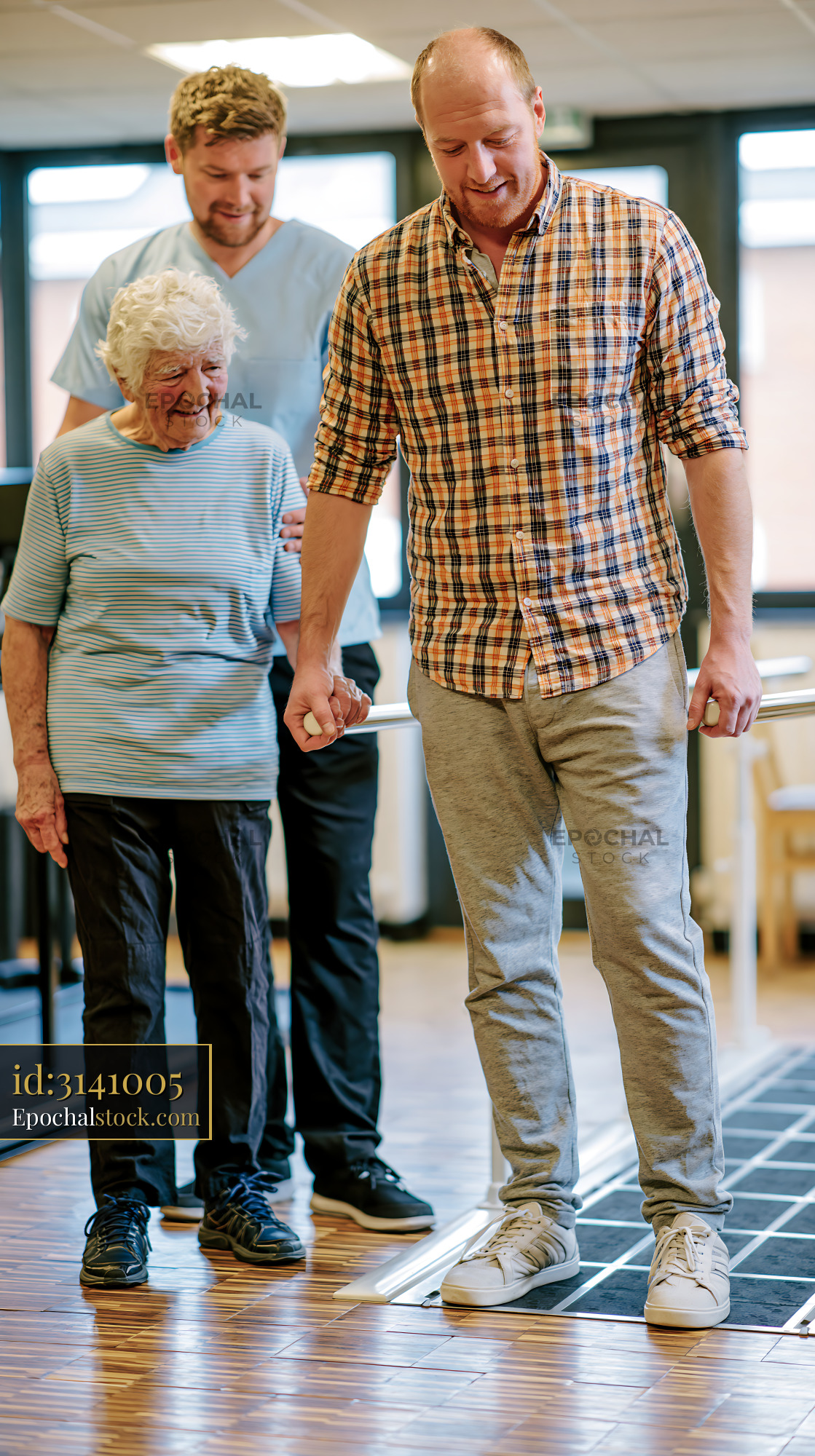 Watermarked full-resolution preview of Senior woman observing physical therapy session with a man