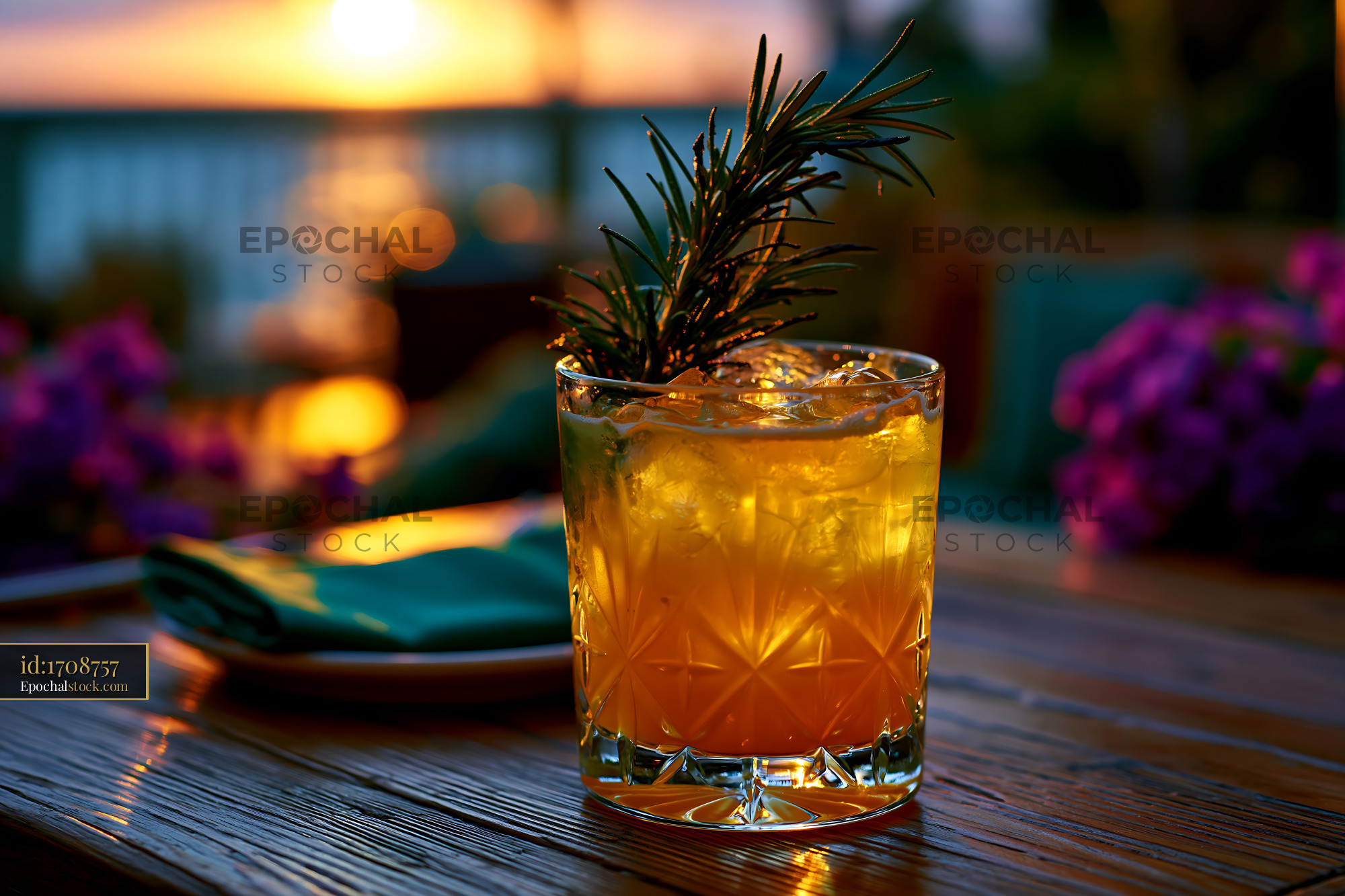 Watermarked full-resolution preview of Sunset cocktail with rosemary on wooden table by the sea