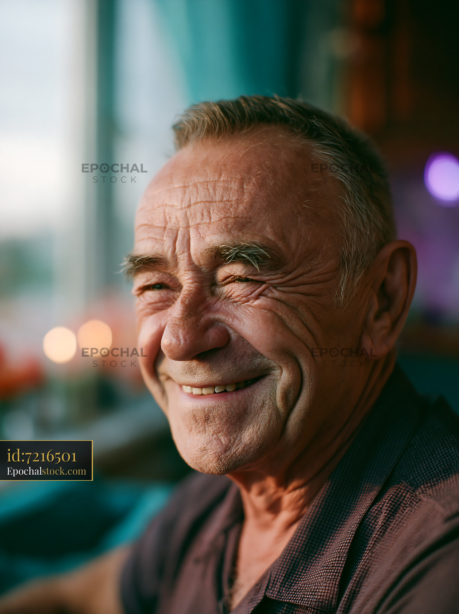 Watermarked full-resolution preview of Smiling man with gray hair sitting indoors by candles