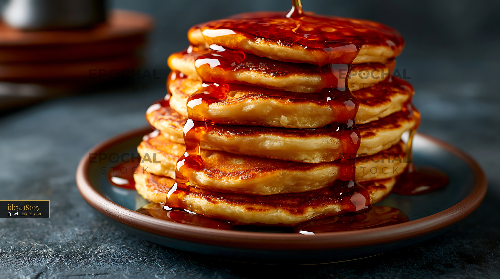 Watermarked full-resolution preview of Stack of pancakes with syrup on a dark plate