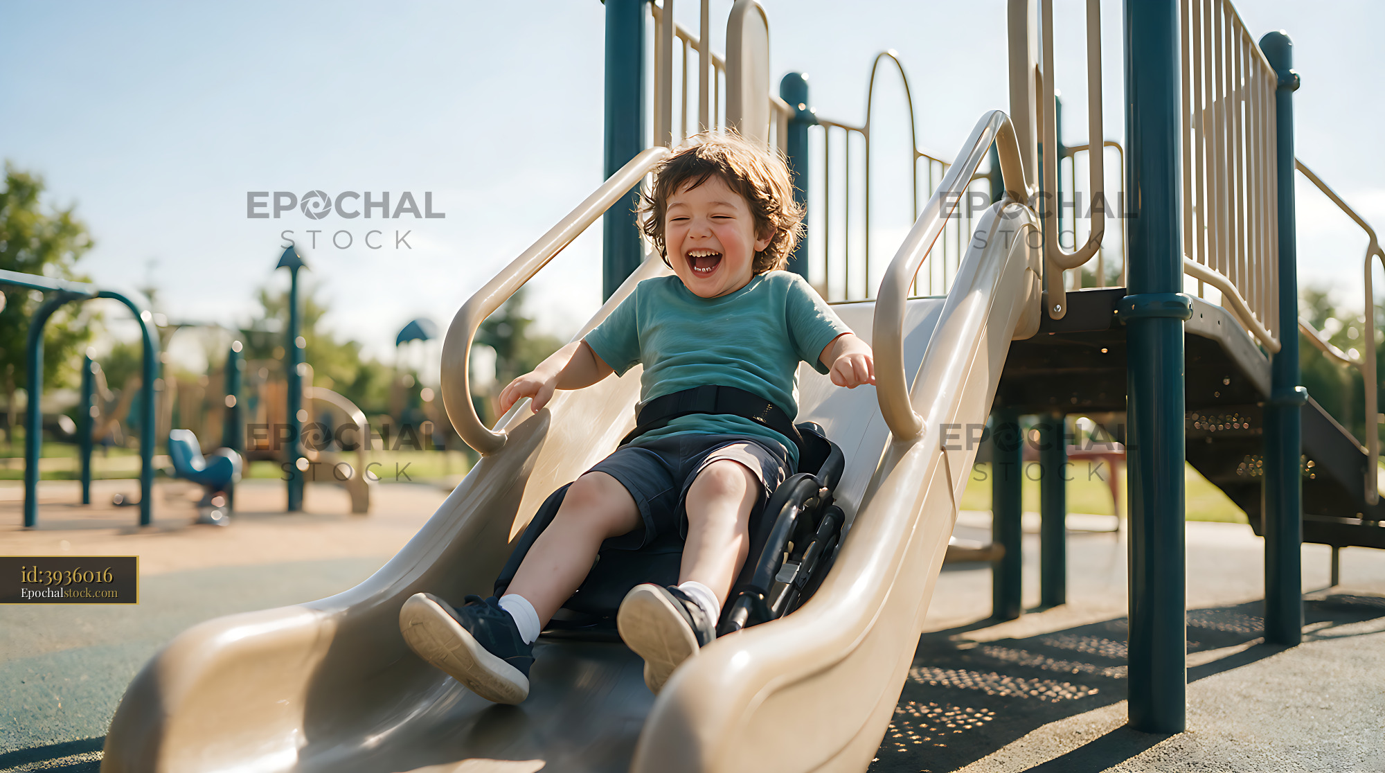 Watermarked full-resolution preview of Disabled child smiling on an inclusive playground slide