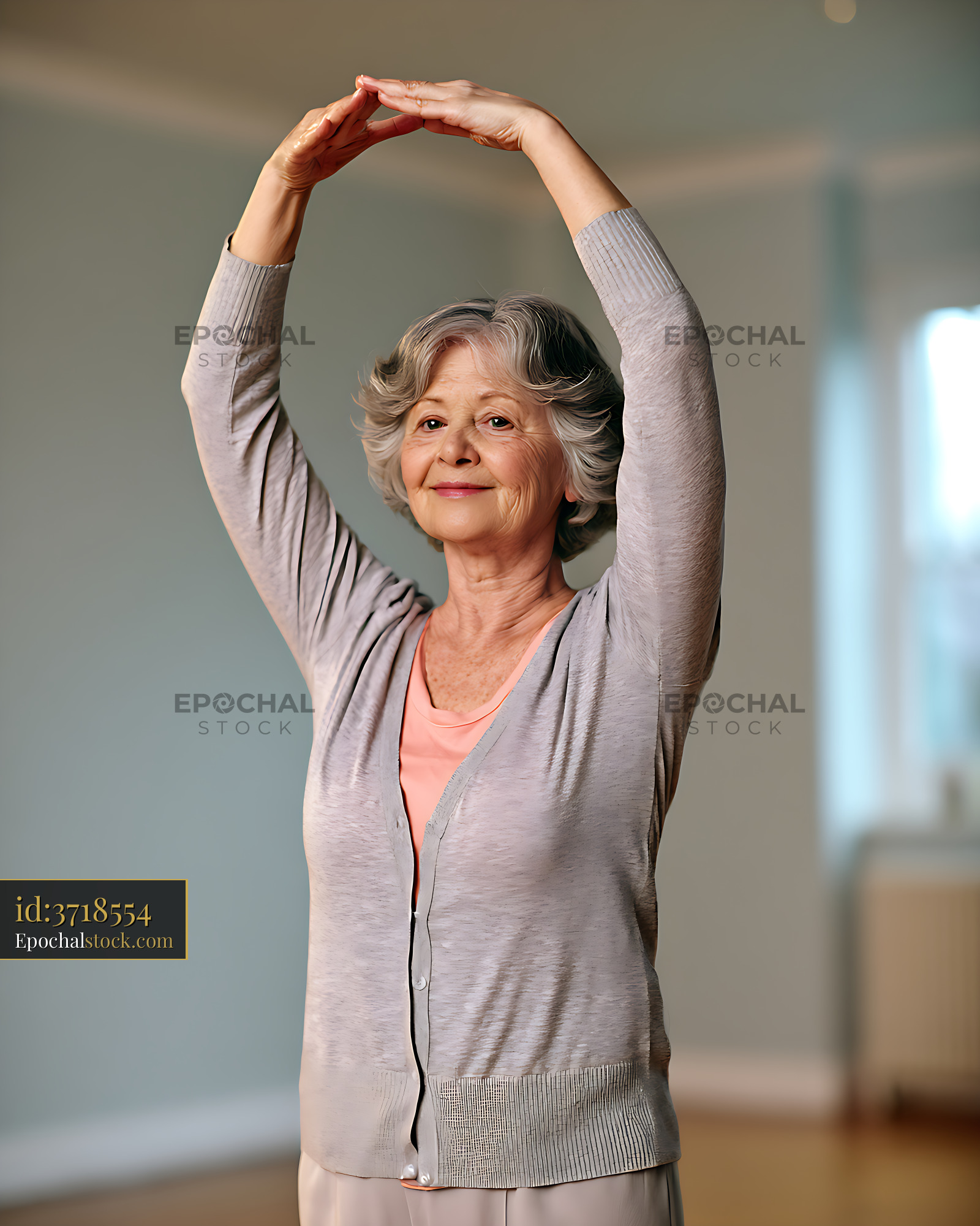 Watermarked full-resolution preview of Older woman doing an overhead stretch at home