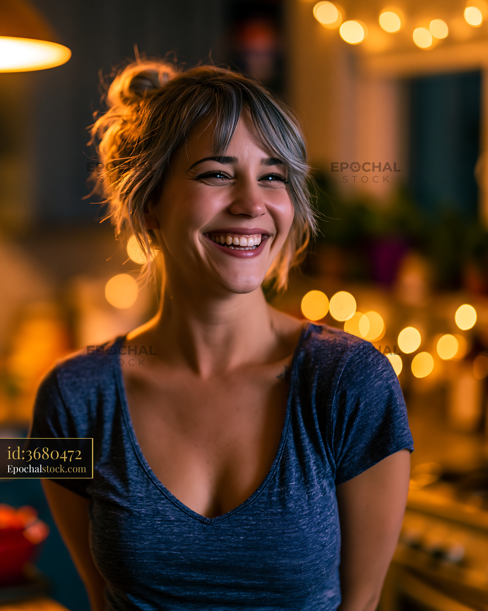 Watermarked full-resolution preview of Smiling woman in a kitchen with glowing lights