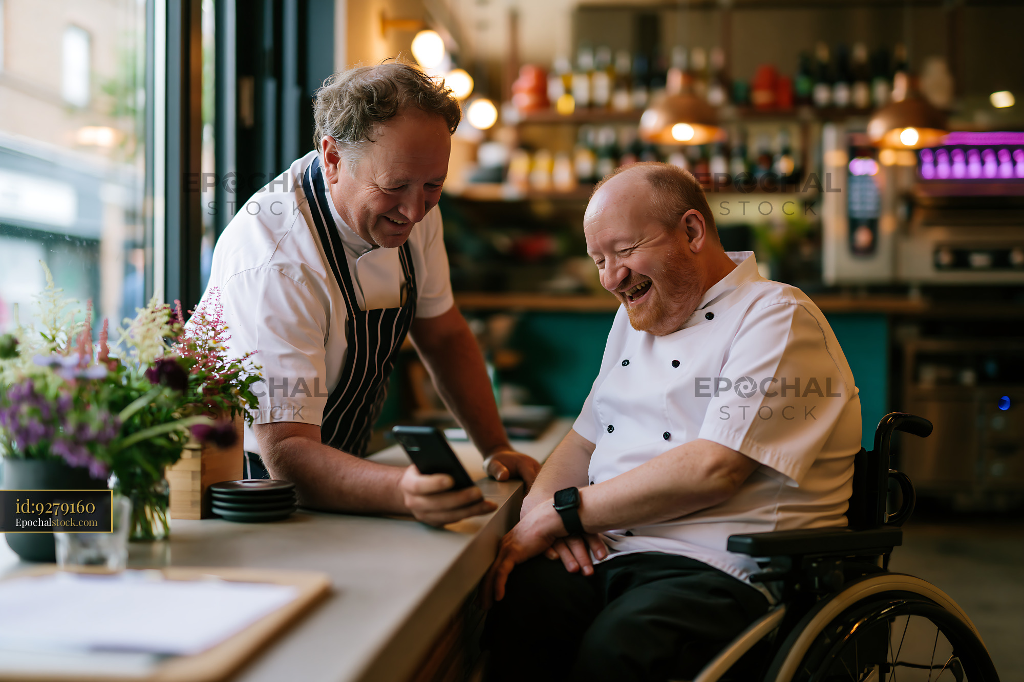 Happy Chef in Wheelchair With Assistant Sharing a Moment - stock photo